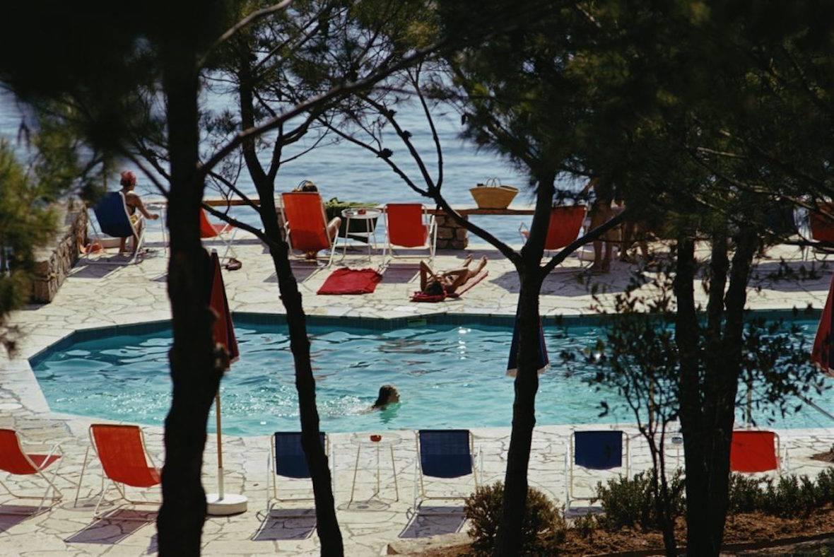 Hotel Il Pellicano" von Slim Aarons

Der Pool am Strand des Hotels Il Pellicano in Porto Ercole, Toskana, August 1973. 

Dieses Foto verkörpert den Reisestil und den Glamour der Reichen und Berühmten dieser Zeit, der von Aarons wunderbar