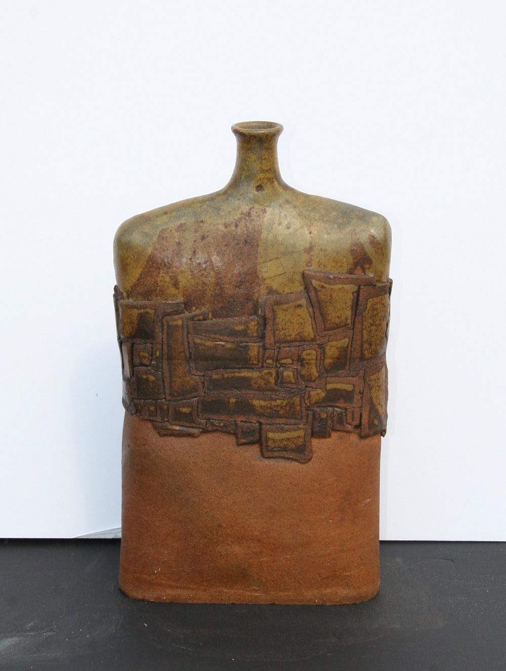 This ceramic sculpture is circa 1970 and offers an expressionistic view of a large flask.  The geometric abstract pattern that separates the two tones lends a modern element to a classic design.

Artist:	Shamel?
Title:	Flask
Year: circa