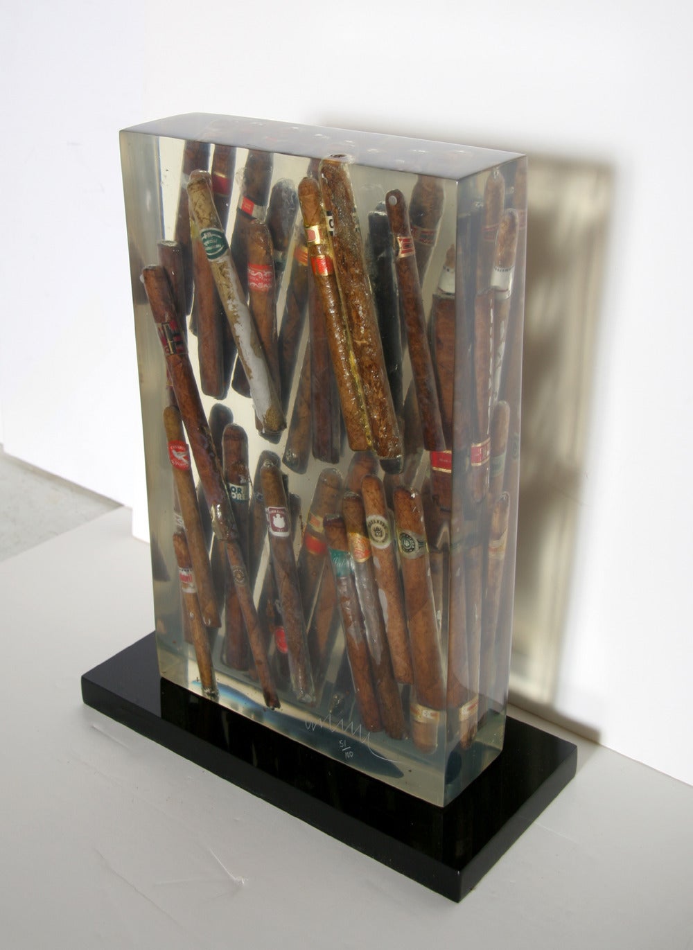 A modern art sculpture by Arman from 1997. The collection of cigars encased in clear resin is a quintessential piece from Arman's 'Accumulations' period in which he took a group of everyday objects, usually mass-produced in nature, and embedded them