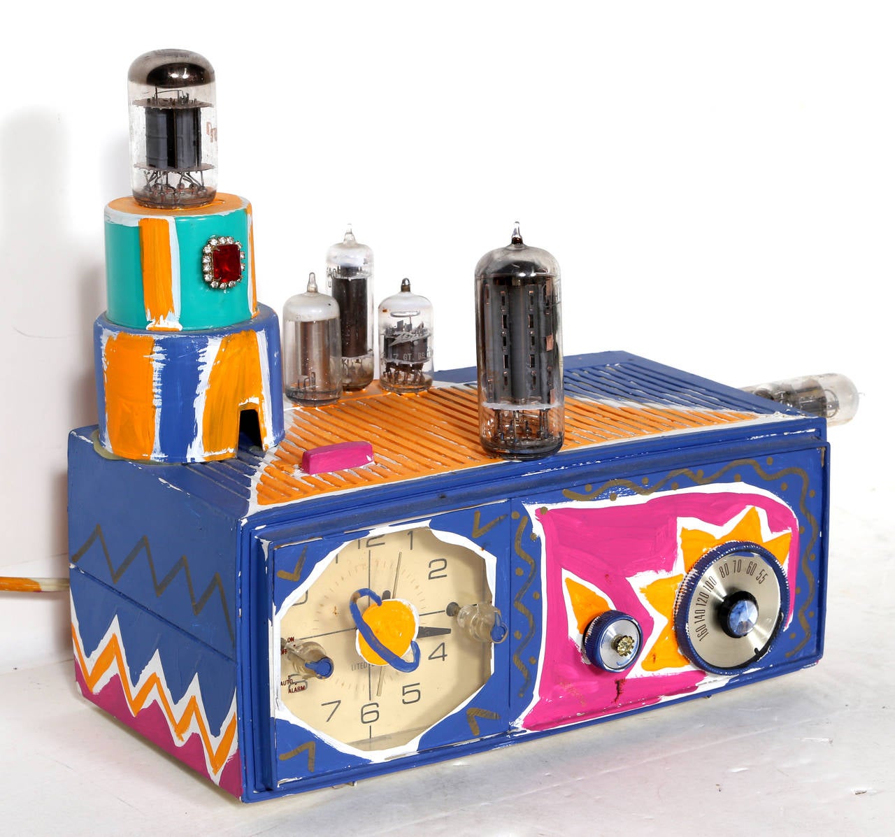 Artist: Kenny Scharf
Title: Clock Radio
Year: 1981
Medium: Acrylic Paint, Costume Jewelry, Electrical Component, Found Object
Size: 12  x 9  x 5.5 in. (30.48  x 22.86  x 13.97 cm)
Illustrated on the Artist
s Website. 