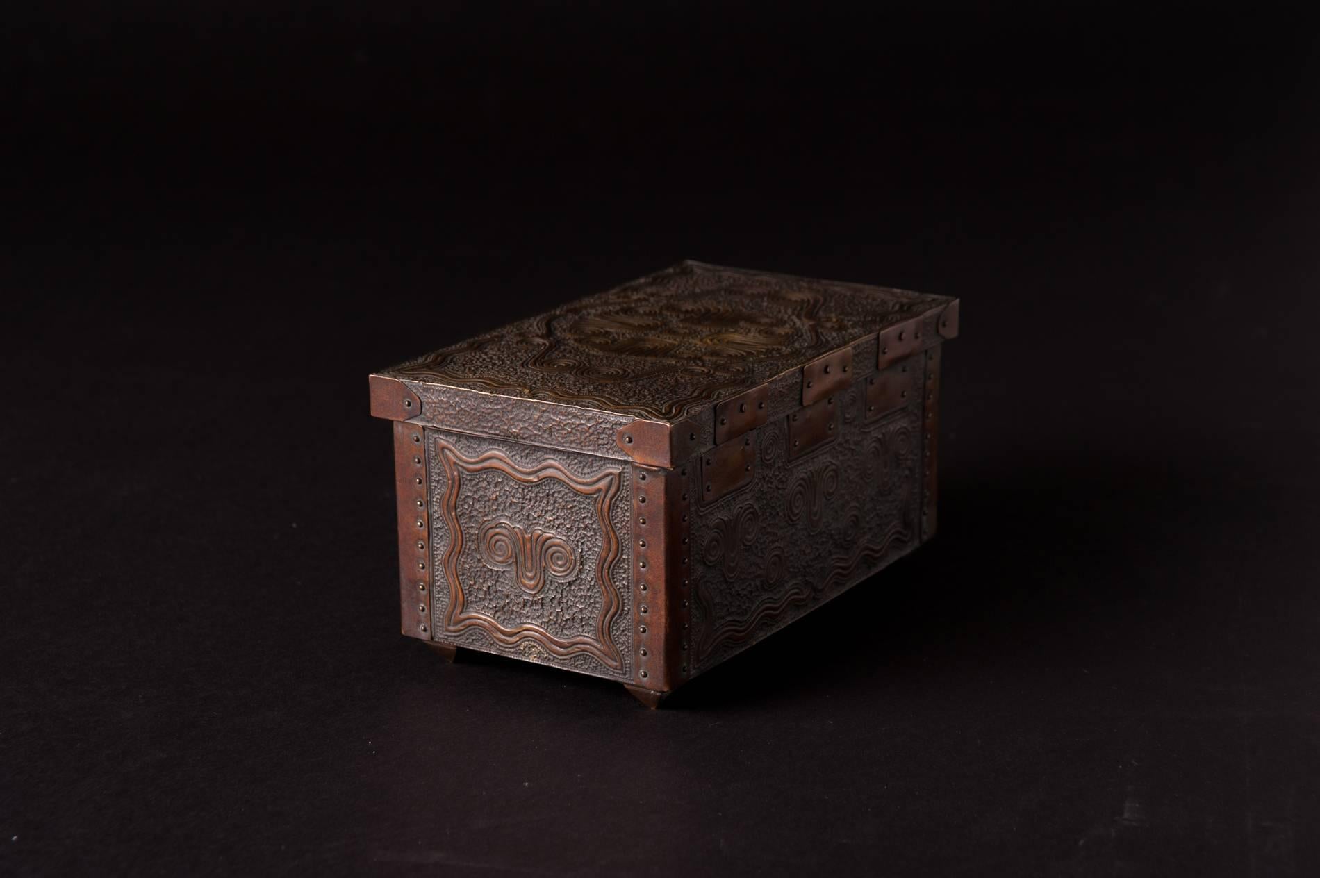 A fine example of metal smithing, this box has been lovingly constructed. The metal cladding is secured by metal coping at the corners and hinge work. Each nailhead is perfectly spaced and evenly secured. Only a craftsman of considerable merit could