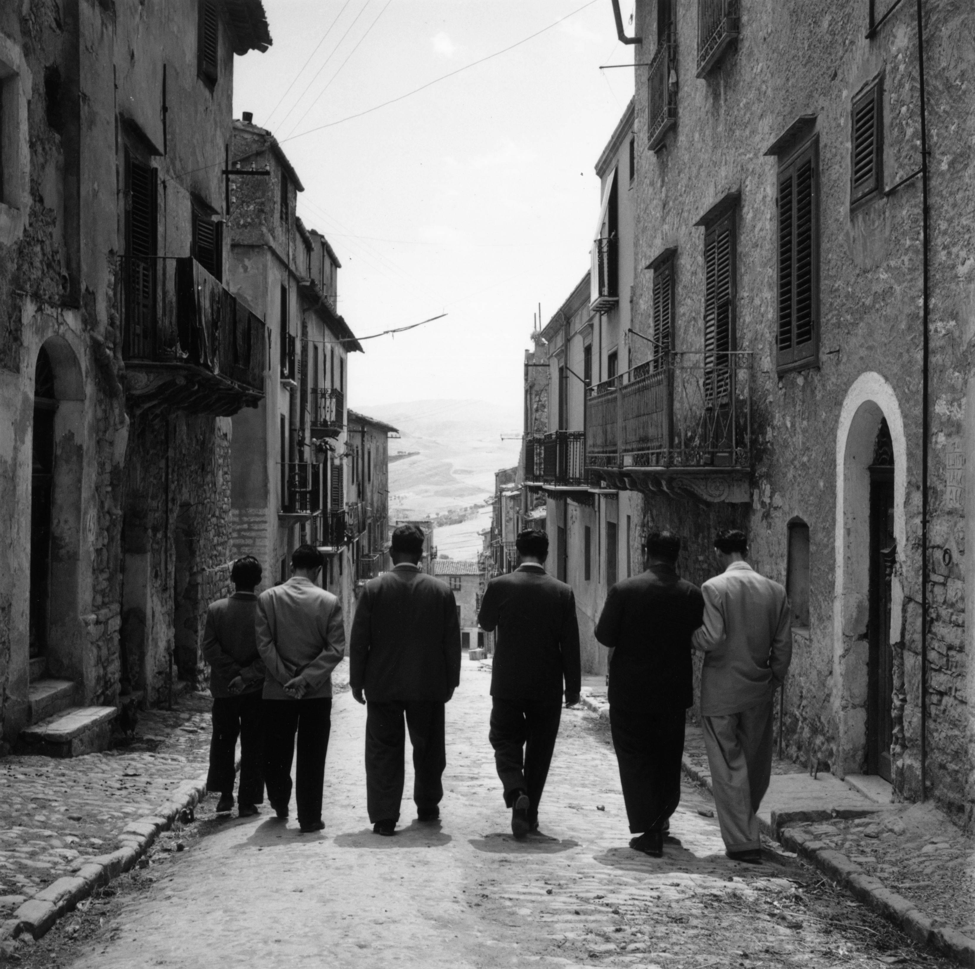 Sicilian-born American gangster Charles 'Lucky' Luciano (1897 - 1962) walking with friends in Lercara, Sicily. His criminal empire included narcotics-peddling, prostitution, extortion and running vice dens. Whilst in prison from 1936 to 1946 he