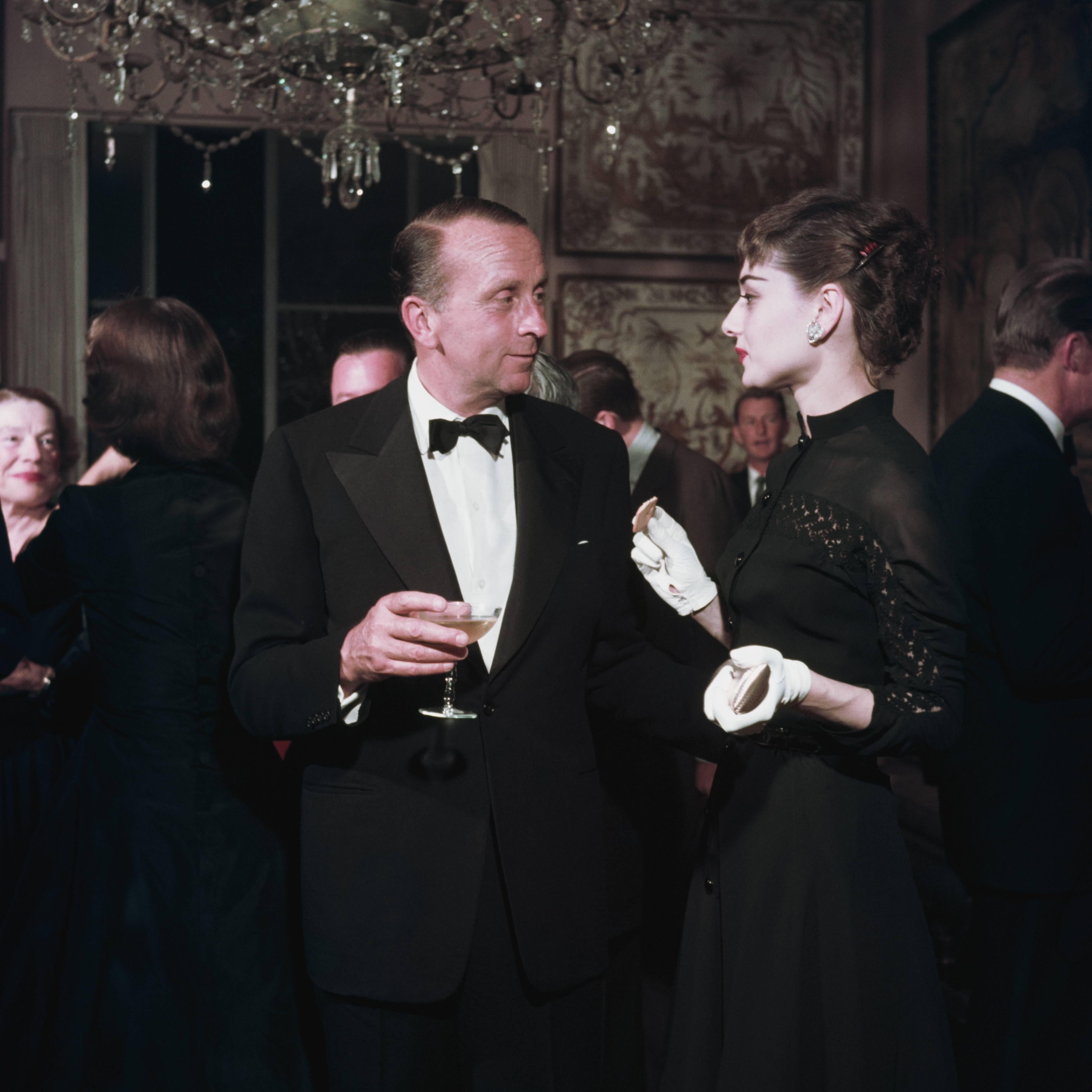 circa 1960: West coast socialite Whitney Warren talking to film star Audrey Hepburn (1929 - 1993) at a party in San Francisco where she is appearing in a production of 'Ondine'. A Wonderful Time - Slim Aarons (Photo by Slim Aarons/Getty
