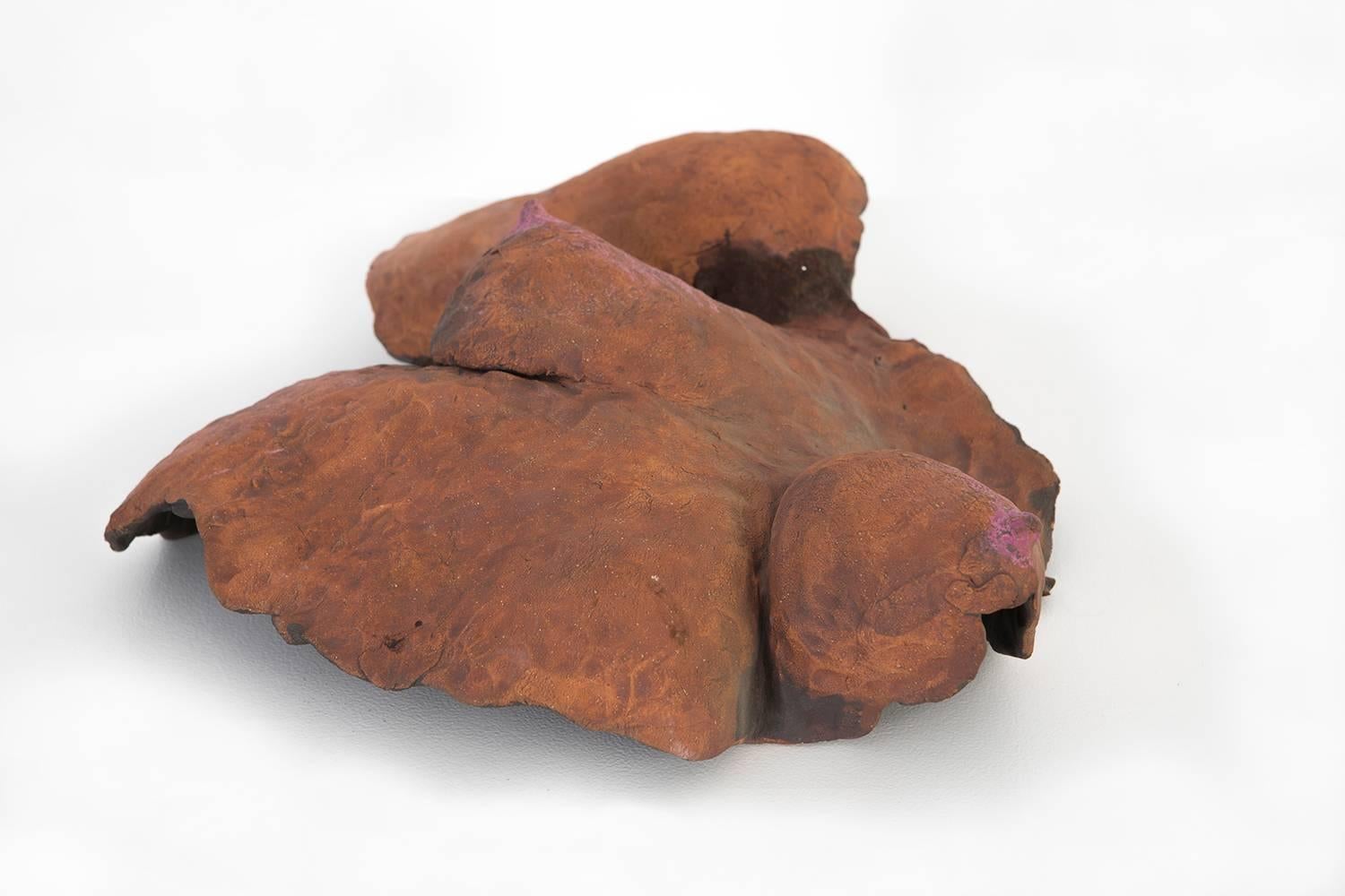 “Young Breasts” by Ruth Aizuss Migdal is sculpted from stoneware with layers and glimpses of orange, pink, and blue oil stick to create a unique and vivid display of color. This piece from 1988 can be hung on a wall for optimum viewing.

This piece