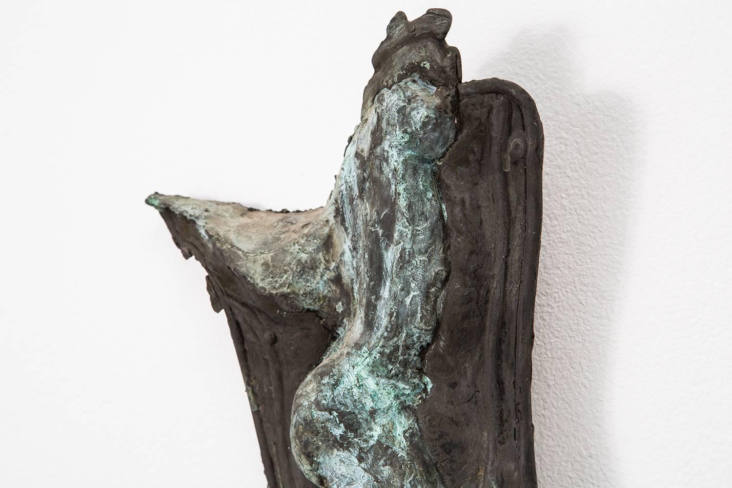 “Poised at Rest” a patinated bronze sculpture by Ruth Aizuss Migdal captures a reclining nude body. The patina provides this piece with a beautiful range of greens and blues that highlight the intricate fold and details.

Through a puzzle-like