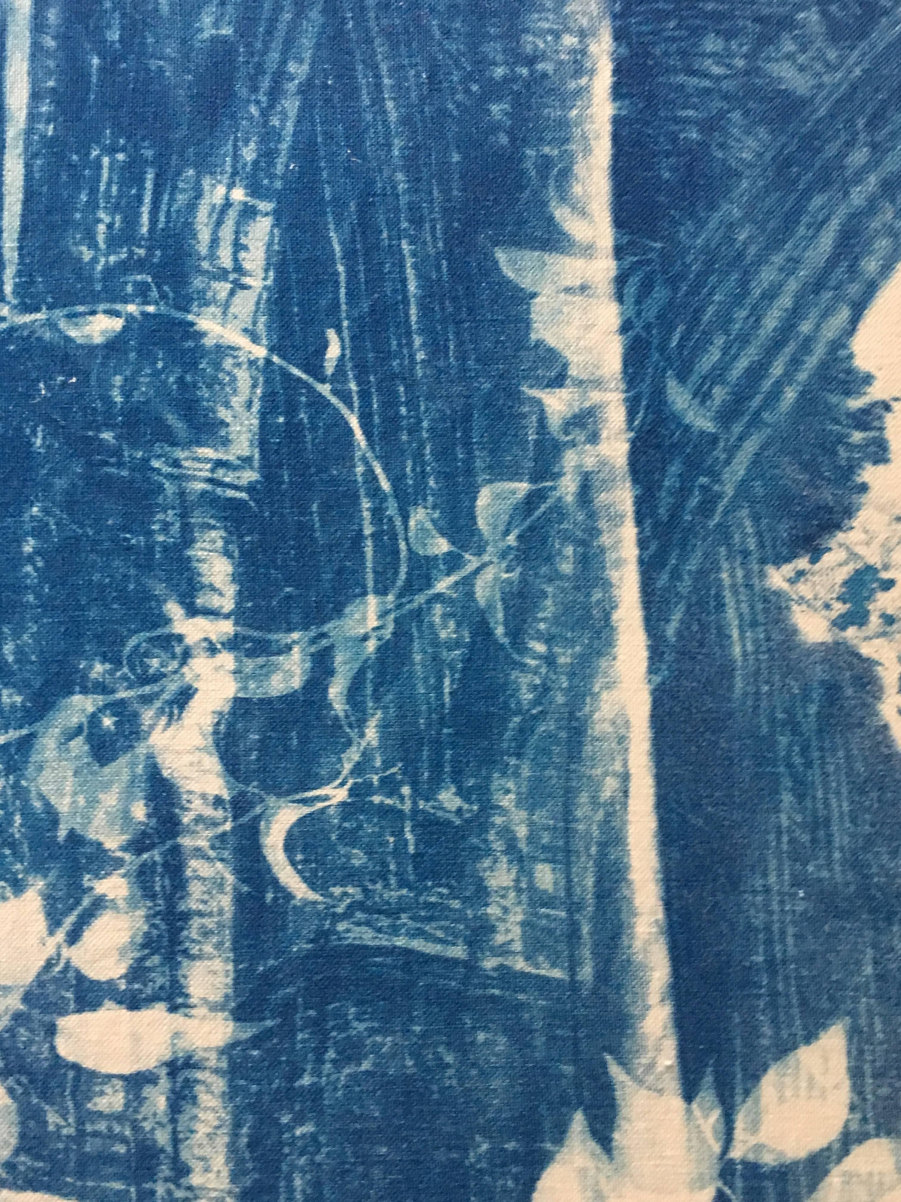 Marie Craig's 'Abbey Ruin 7’ is an original deep blue photograph of the architectural ruins of an Abbey partially obscured with vines and branches. This piece was created using cyanotype, an early photographic process which uses sunlight to expose