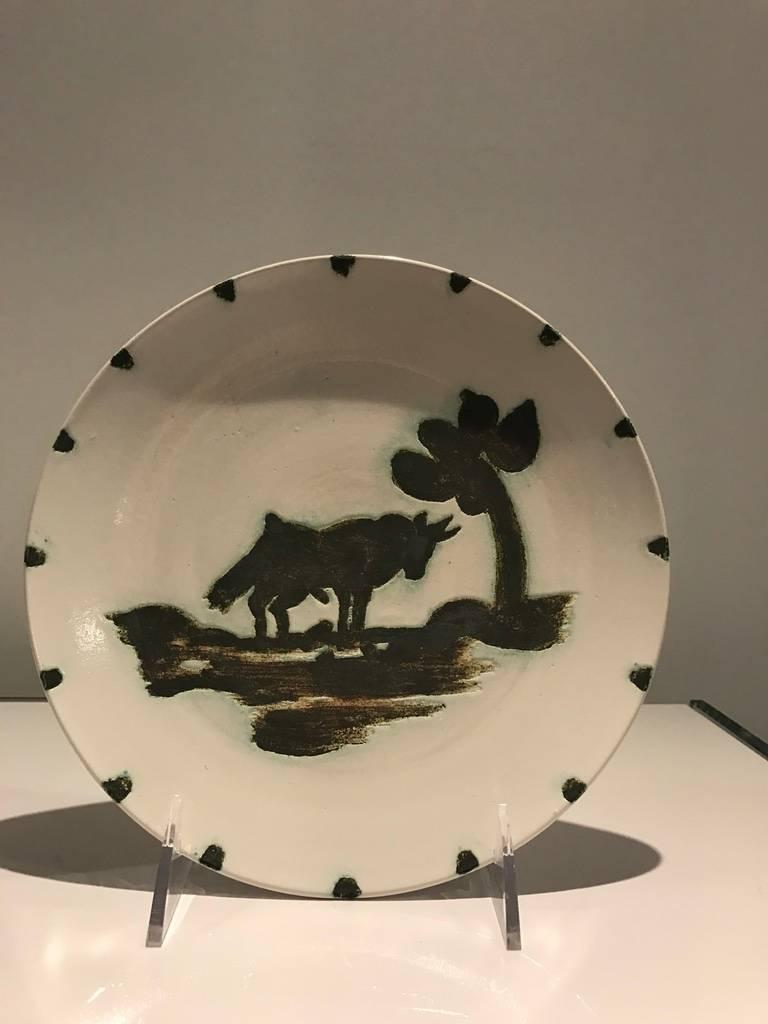 ARTIST:Pablo Picasso
TITLE:  Bull Under the Tree
DATE:1952
MEDIUM:partially glazed ceramic round plate painted in black and white
SIGNED:Inscribed, Stamped on back
NUMBERED:From an edition of 500 pieces - Lower Left
DIMENSIONS:7.5 X 7.5