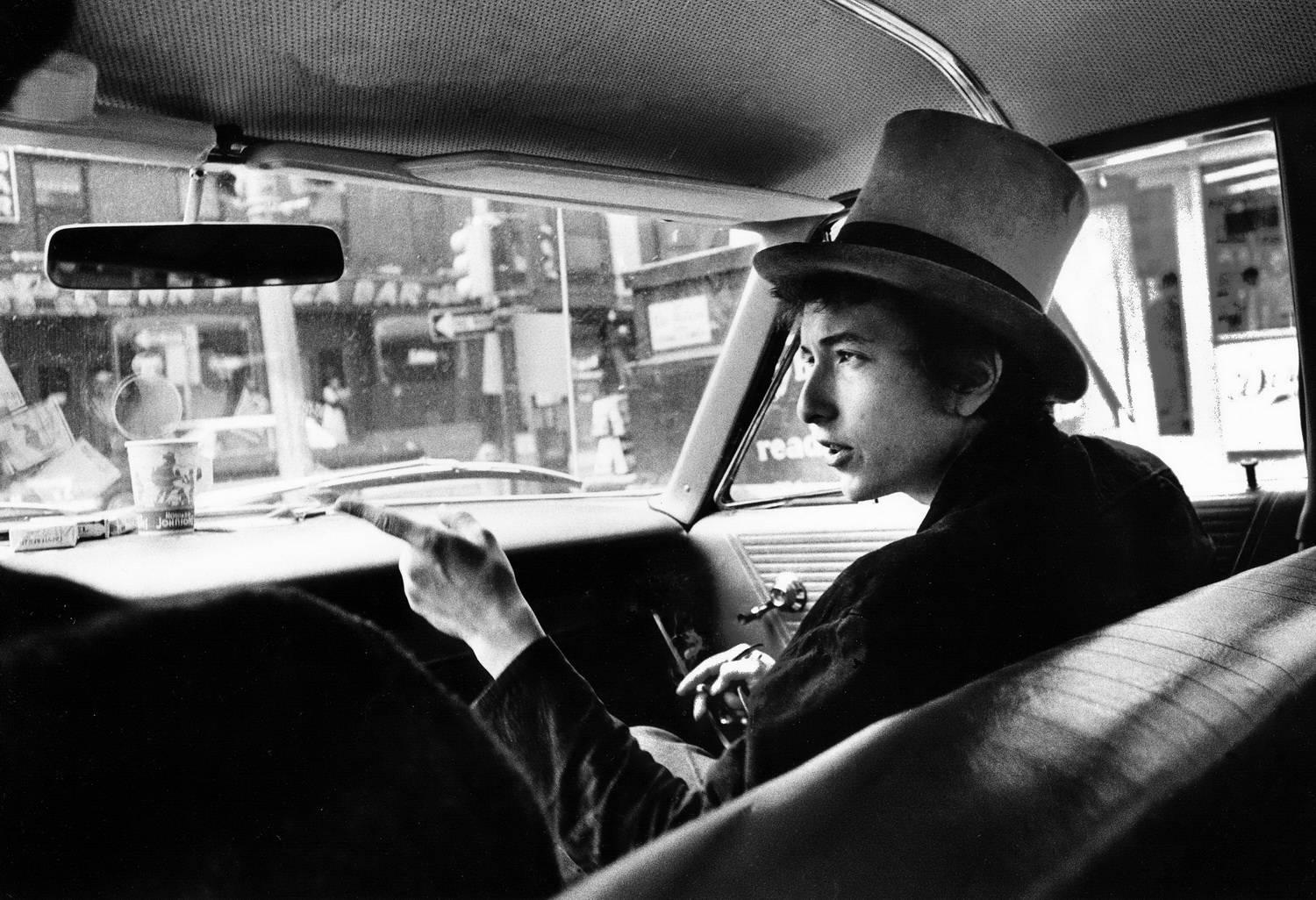 Daniel Kramer Black and White Photograph - Bob Dylan with Top Hat Pointing In Car, Philadelphia, PA