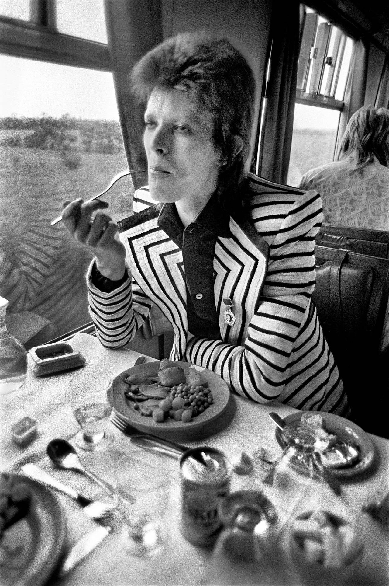 Mick Rock Portrait Photograph - Bowie Eating on Train