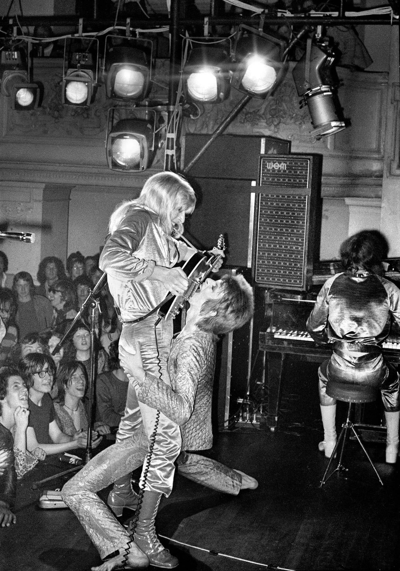 Mick Rock Black and White Photograph - Bowie and Ronson, Guitar Fellatio