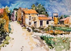 Paesaggio di una stradina di un paesino francese inondata di sole, con case in pietra e tetti in terracotta