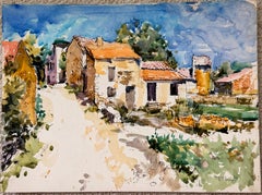 Paesaggio di una stradina di un paesino francese inondata di sole, con case in pietra e tetti in terracotta