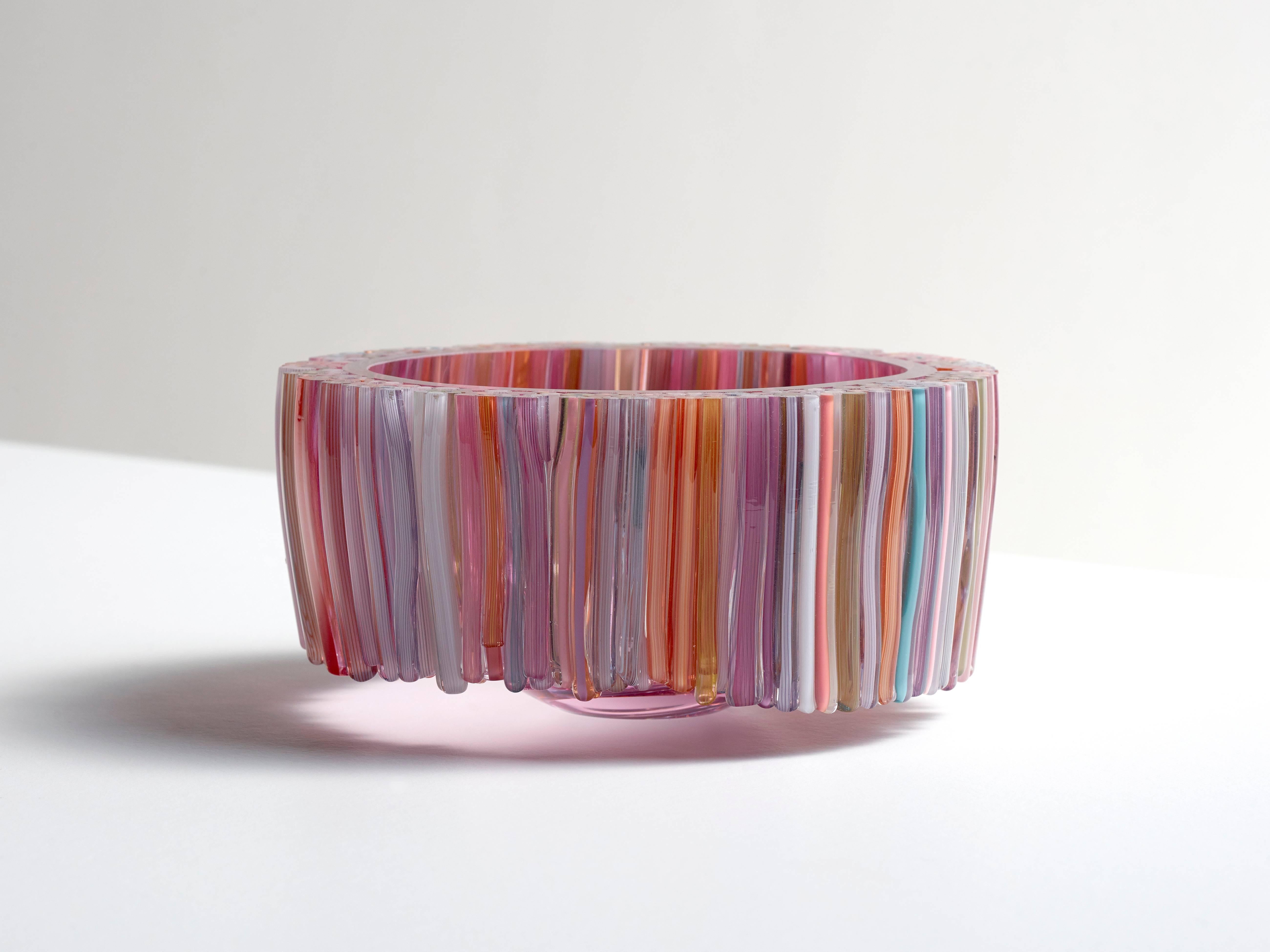 This beautiful blown glass red bowl is decorated with hand crafted glass threads that are melted to the body of the glass vessel. The many colors of the threads like, green, pink, blue, orange and white are stylishly combined, resulting in a playful