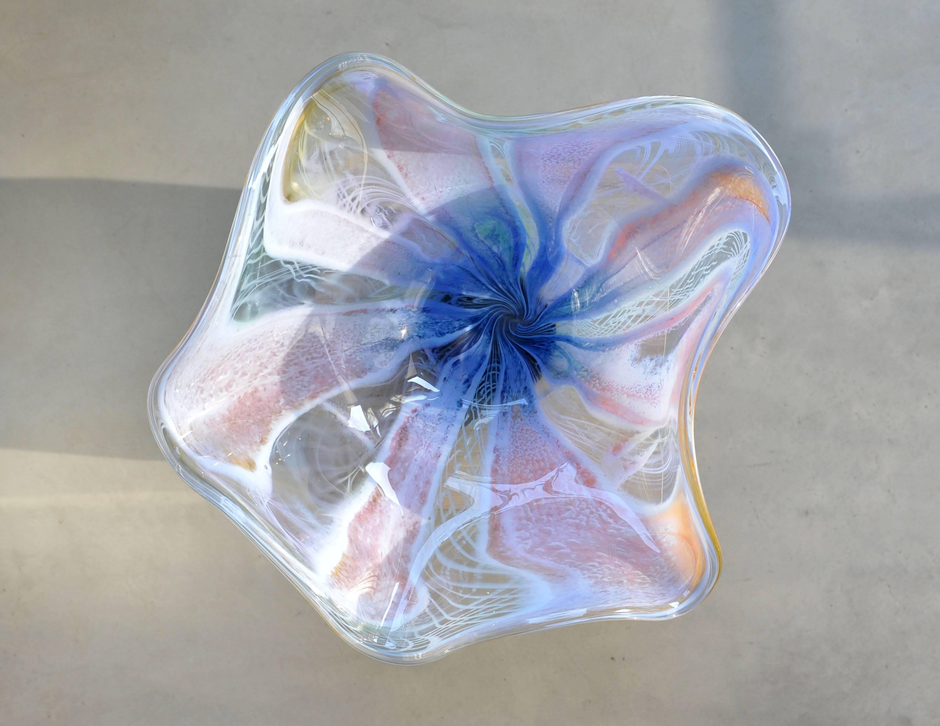 This beautiful, multi colored blown glass decorative bowl, created by glass artist Richard Price, is a majestic free-form centerpiece and a jewel for the interior. Translucent color patterns are playing the eye. It is a unique piece that comes with