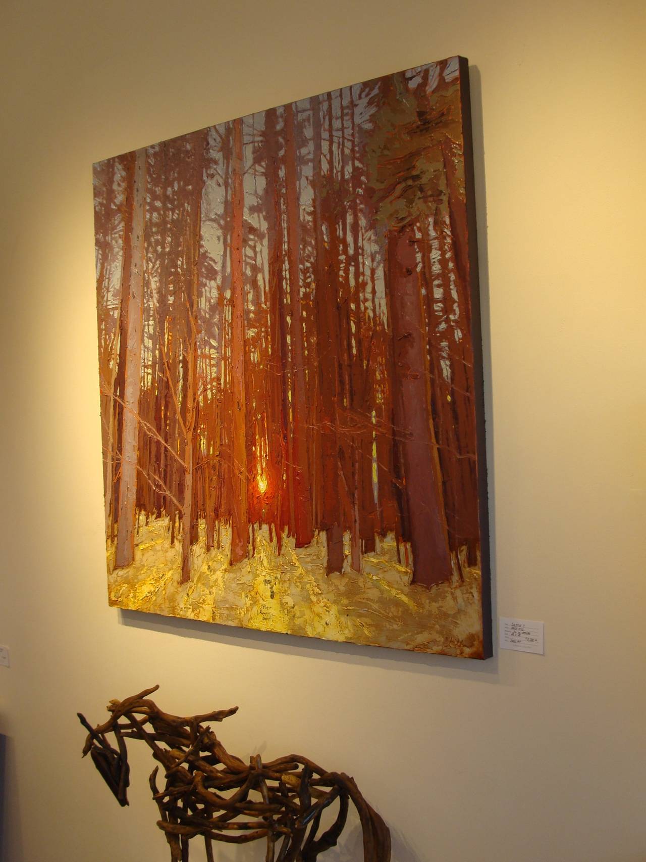 Fiery light flits through majestic trees, illuminating a lushly green forest floor. The paint is applied thickly using a palette knife. Gold leaf is incorporated in the painting to create reflection of sun on the forest ground. 

Born and raised