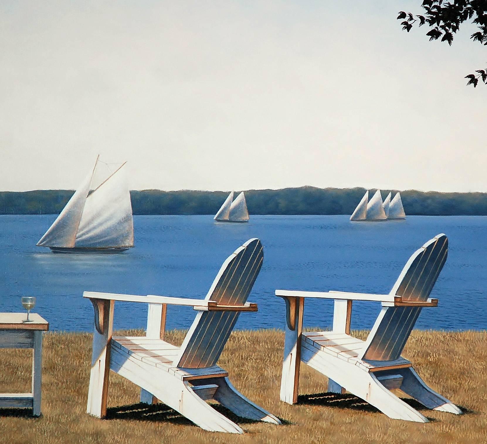 This traditional coastal oil painting by Daniel Pollera features three white Adirondack chairs, positioned in the grass overlooking a body of water. Several sailboats can be seen close up and further out along the horizon line. A pale blue sky fades