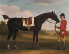 A DARK BAY HORSE HELD BY A LIVERIED GROOM IN A LANDSCAPE