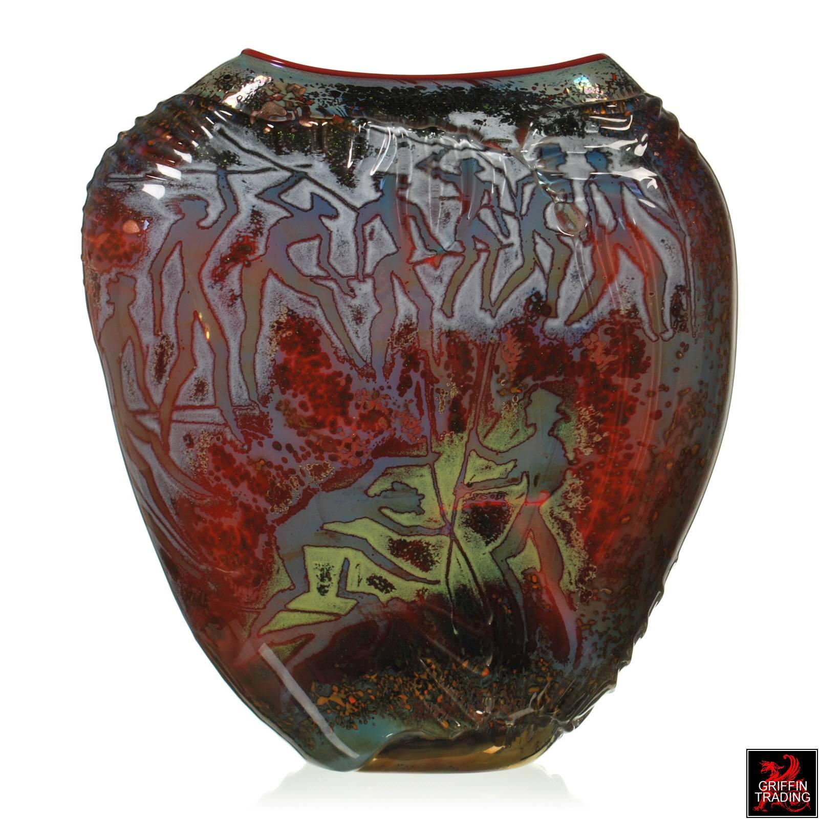 This monumental art glass vessel is the work of American glass artist William Morris. Part of his Petroglyph series done in the 1980′s, this striking art glass vase is decorated with various forms of tribal petroglyphs. Emblazoned with primitive