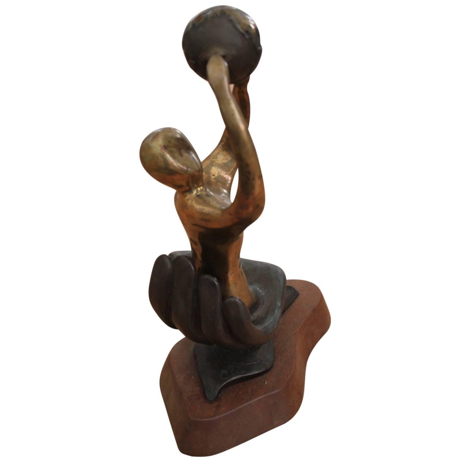 Abstrakte figurative Skulptur einer Frau, die eine Weltkugel über ihrem Kopf hält und in einer Handfläche sitzt. Die Bronzestatue steht auf einem Holzsockel. Er wurde 1986 als Houston Service Award verliehen. Der Künstler hat das Werk signiert,