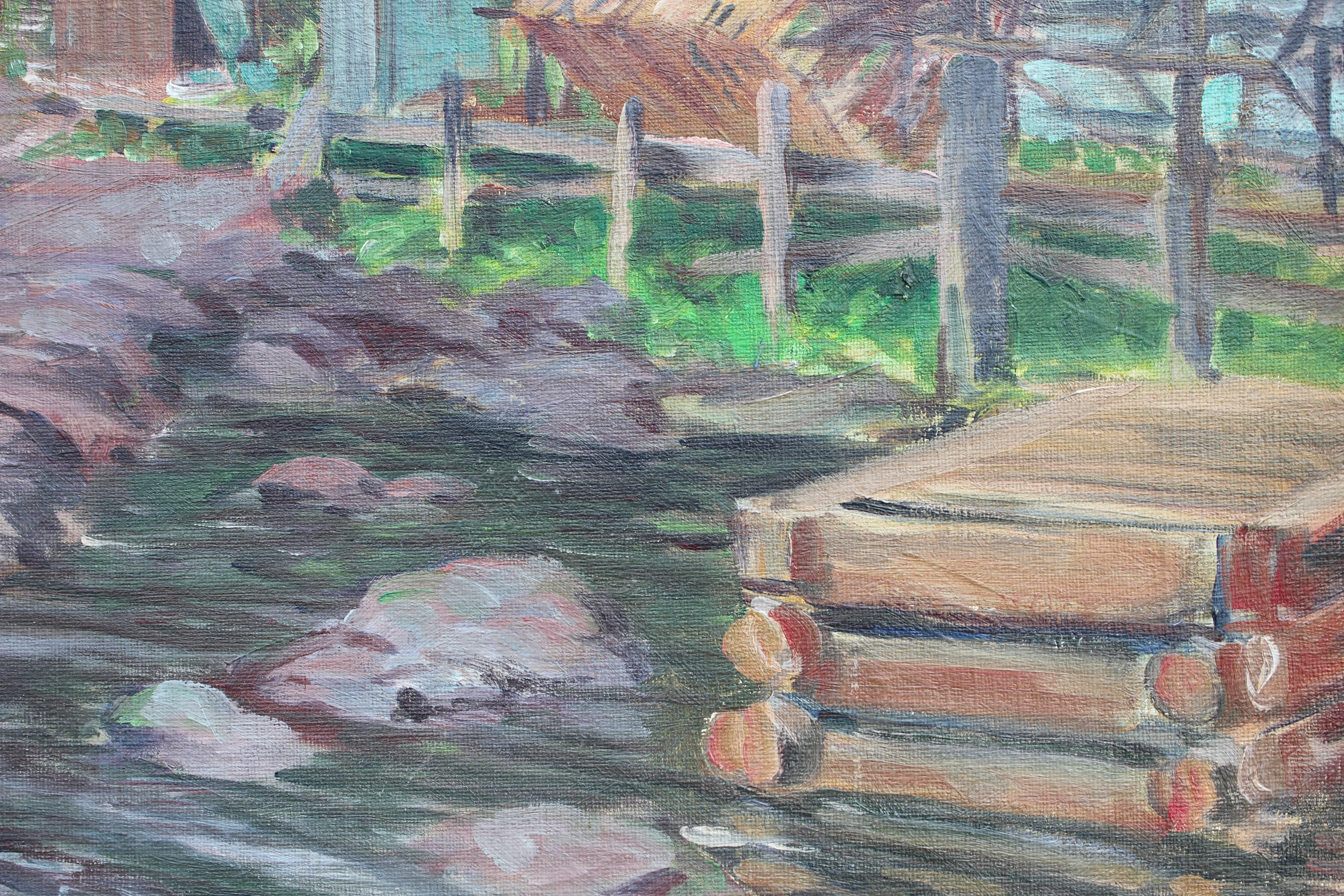 Naturalistic landscape of a riverside with boat houses and small boats on the banks. The painting is signed by the artist and dated. It has a short passage about the painting's relation to the artist. It is framed in a wooden frame with a cream