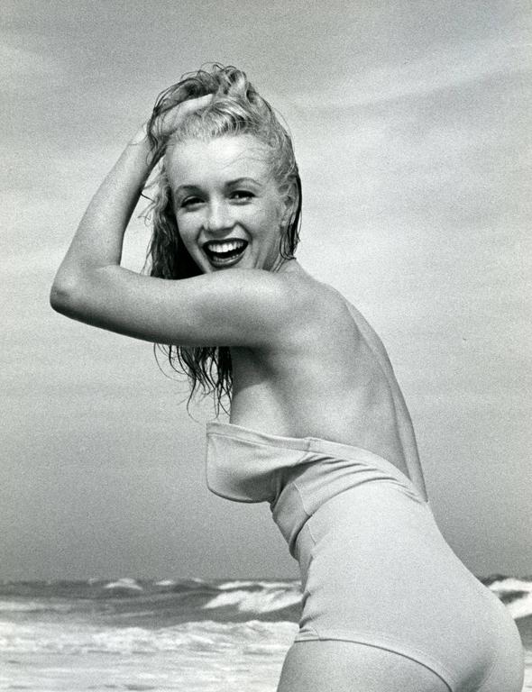 Incredible vintage origianl Oversized Andre De Diennes photograph of Marilyn Monroe playing on the beach in Long Island NY.  Marilyn os captured smiling looking over her left shoulder with hands in her hair.  Back stamped by Andre De Diennes from