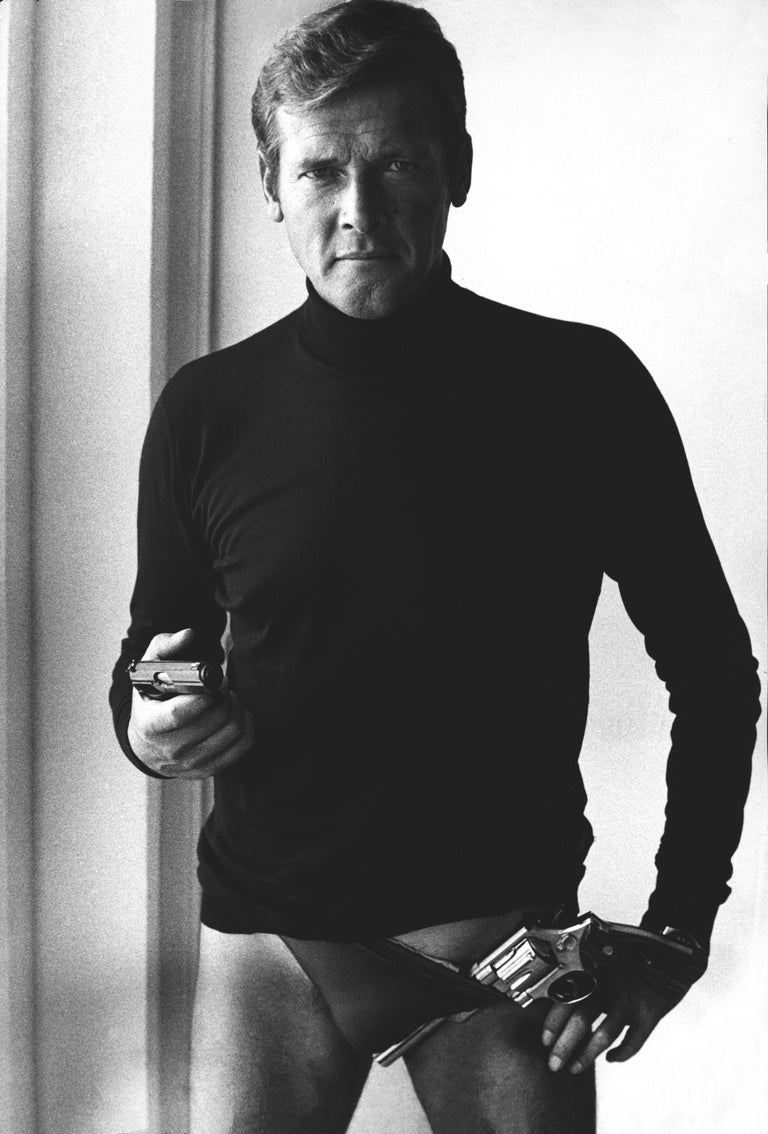 John Bryson Black and White Photograph - Roger Moore as James Bond With Gun in Underwear Fine Art Print