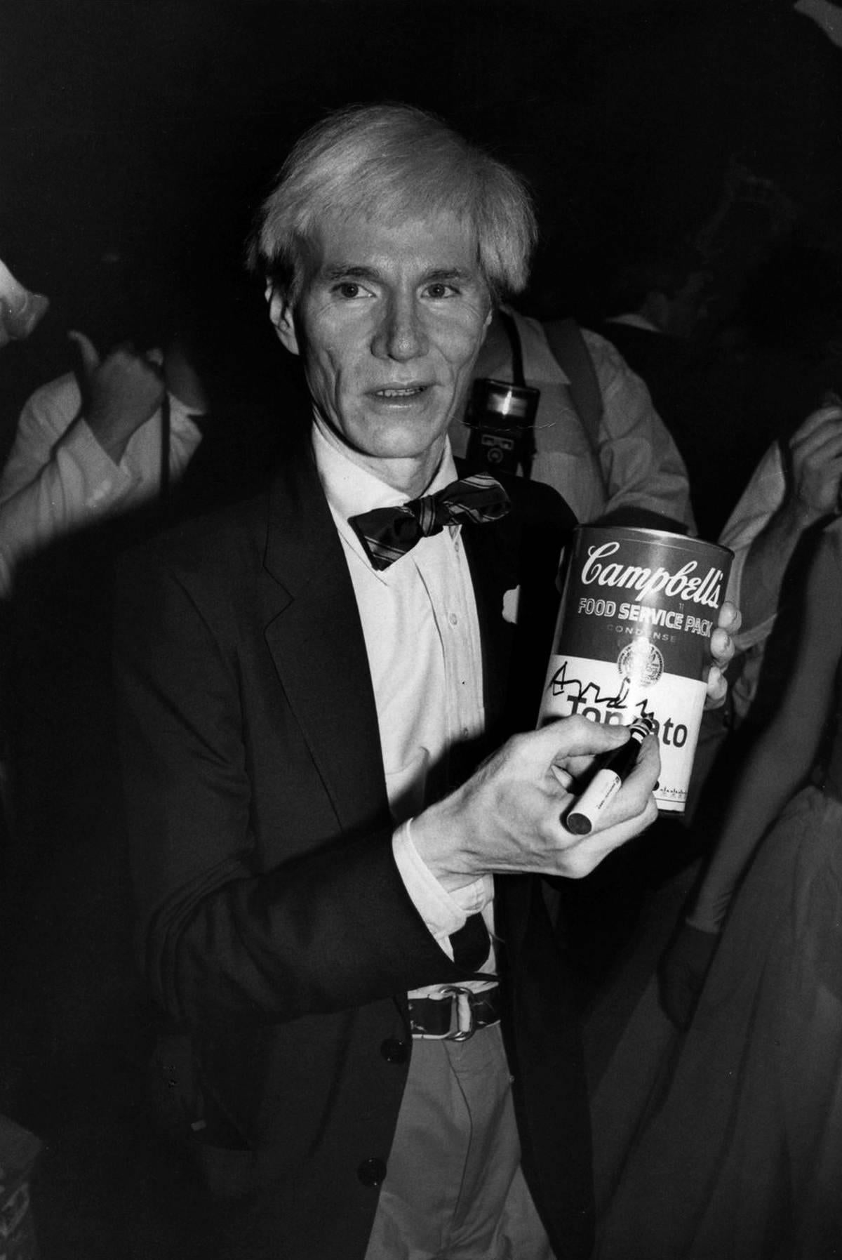 Adam Scull Black and White Photograph - Andy Warhol Autographing a Campbells Soup Can Fine Art Print
