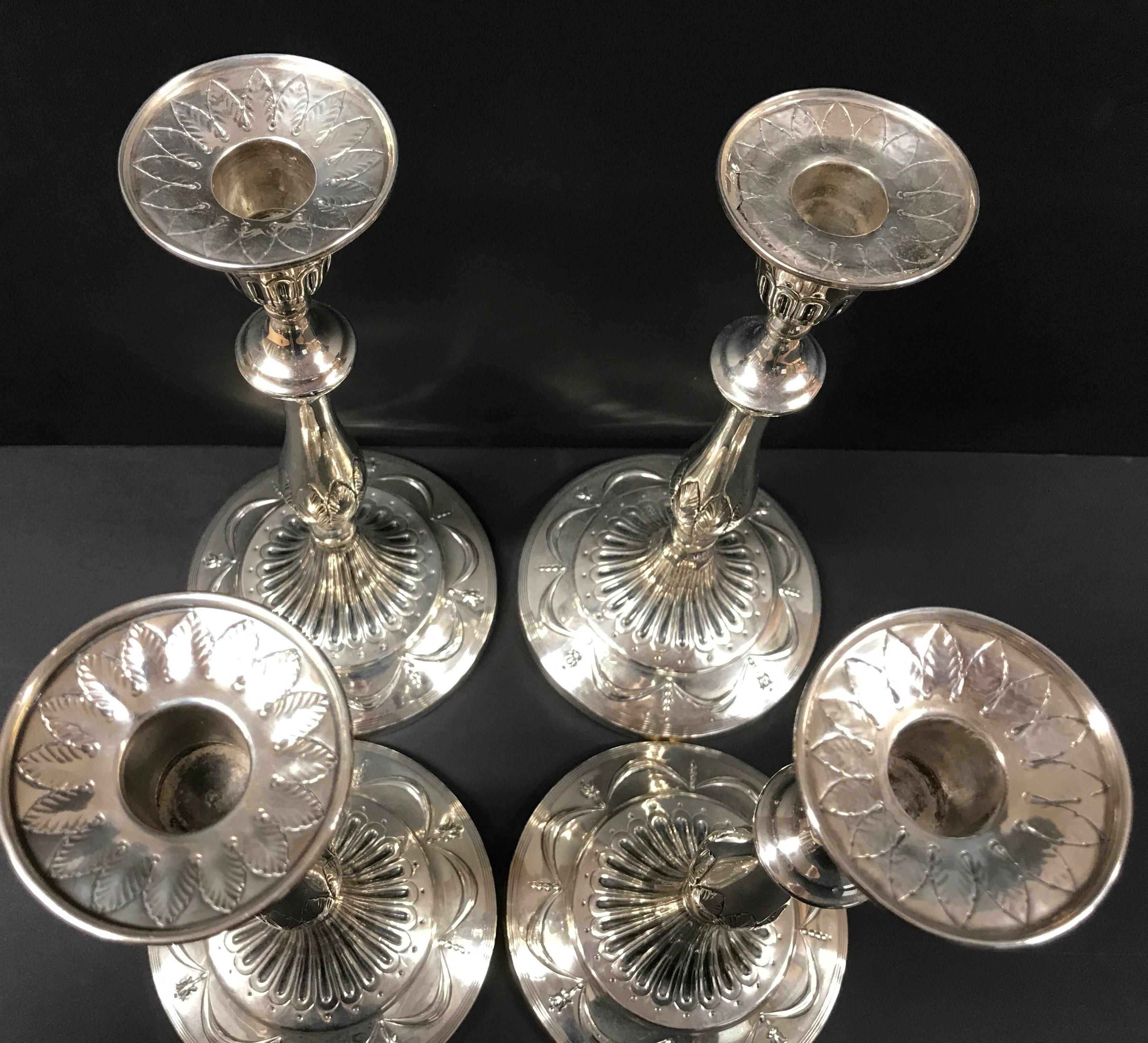 Amazing George III Sterling Silver  Set of four (4)  sterling silver candlesticks  c. 1799  Neoclassical style sterling silver candlesticks, fluted urn shaped sockets, repousse laurel leaf decoration to the round bobeches and standards, knopped