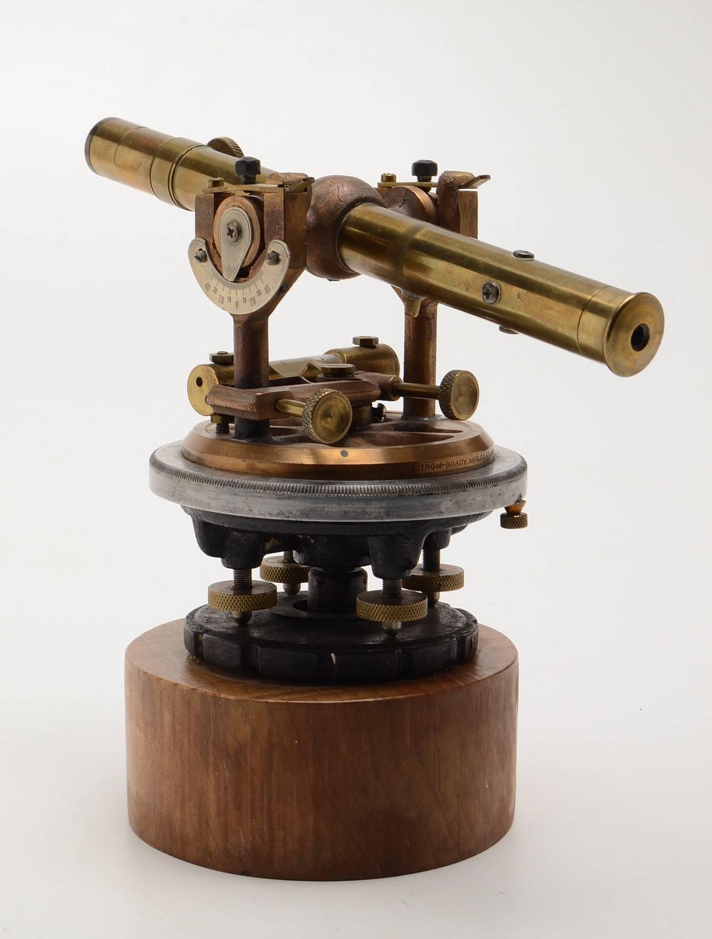 An antique brass surveyor’s transit, mounted to a curly maple plinth base  Manufactured by Bostrum-Brady  Marked “MFD By Bostrum-Brady Mfg Co., Atlanta, GA”   In very good working condition.

Ernst Alfred Bostrom (1855-1923) was a Swedish immigrant
