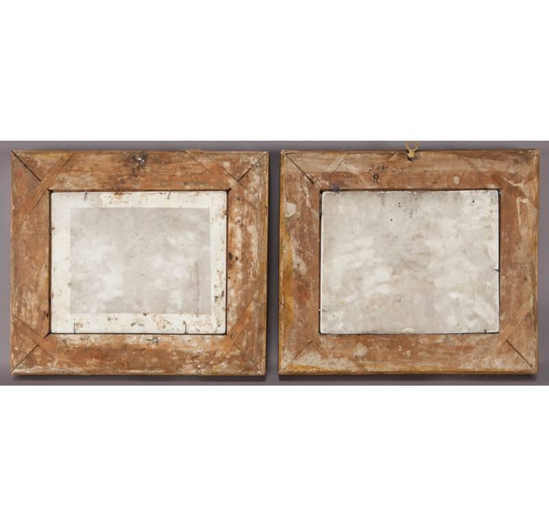 Pair of antique Napoleon III porcelain plaques in gold leaf frames from France, circa 1870, depicting two different interior scenes with Napoleon III soldier trying to seduce a young woman on one,  while another man is charming another woman on the