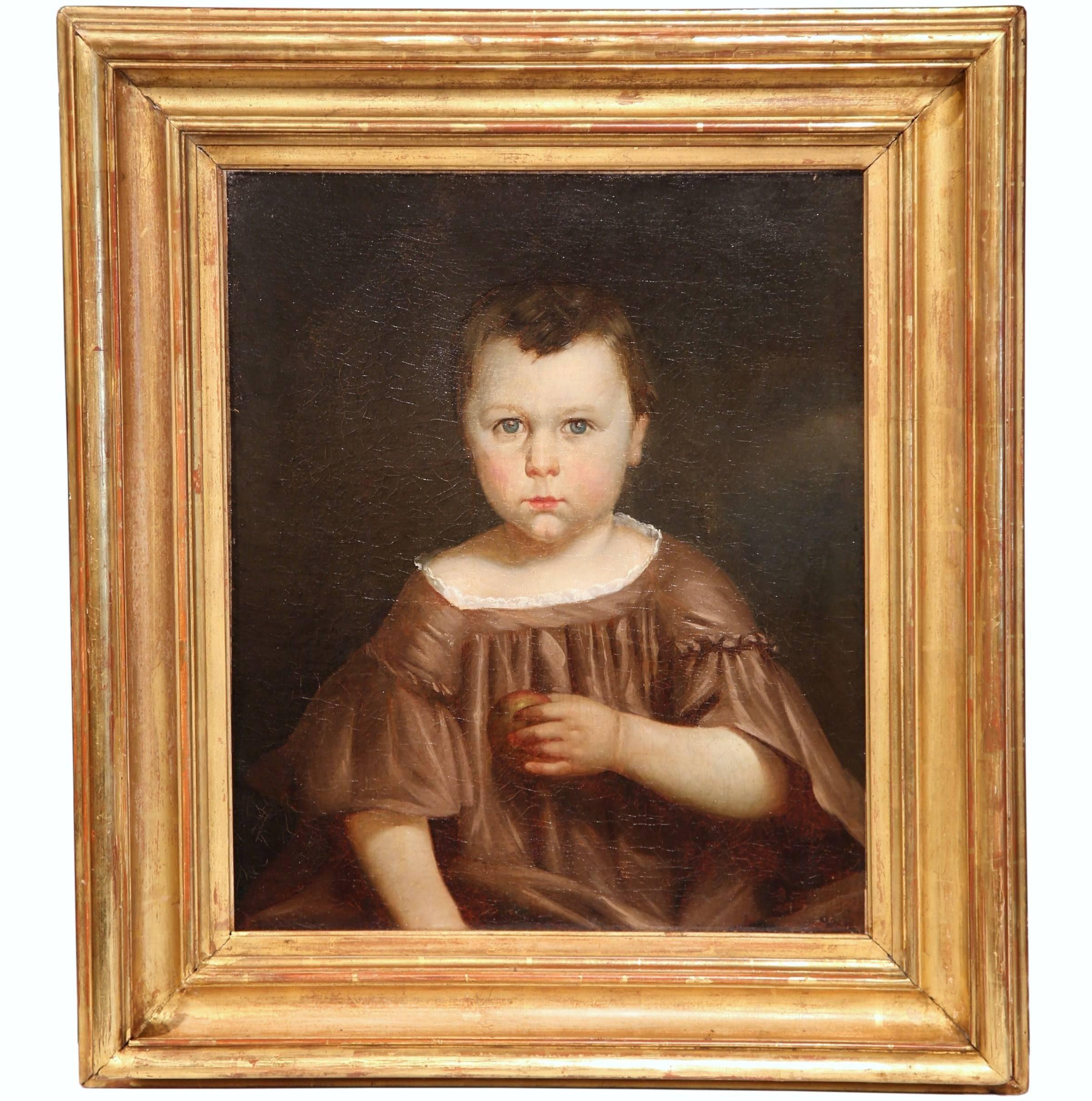 This highly detailed oil on canvas was painted in France circa 1820. The high quality portrait features a young boy in traditional clothing holding an apple in his left hand. The figure has a strong, piercing gaze and a beautiful facial expression.