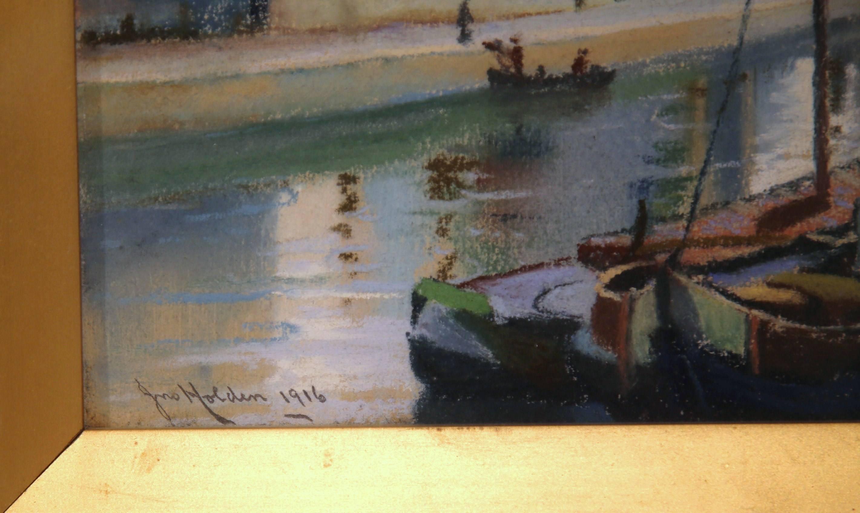 This fine pair of antique watercolors was painted in England, and is signed and dated Holden, 1916. The compositions show two cityscapes situated on a river. The color palette is soft and neutral, and the pieces are covered with clear glass. The