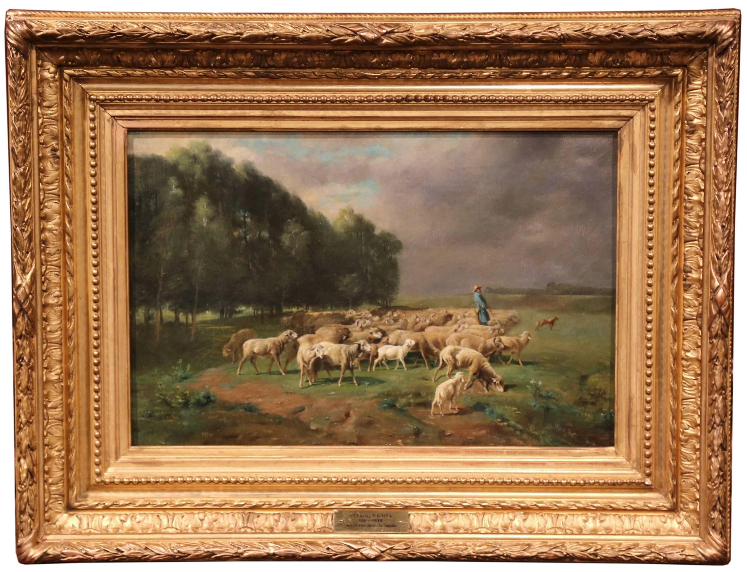 This beautiful, antique oil on canvas was painted in France circa 1900. The bucolic artwork features a herd of sheep grazing in the moor while a shepherd is looking over his flock. The piece has a front plaque which reads Charles Clair (1860-1930)
