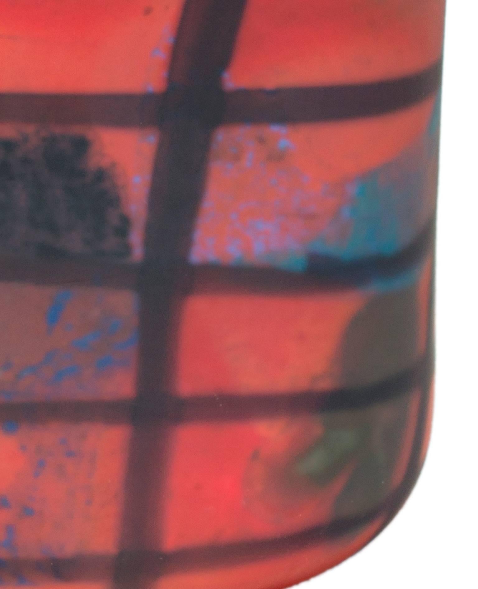 This vase was made of hand-blown glass by Ioan Nemtoi. It is square and matte and features orange-red ground with black, yellow, and blue designs. 

9 1/2
