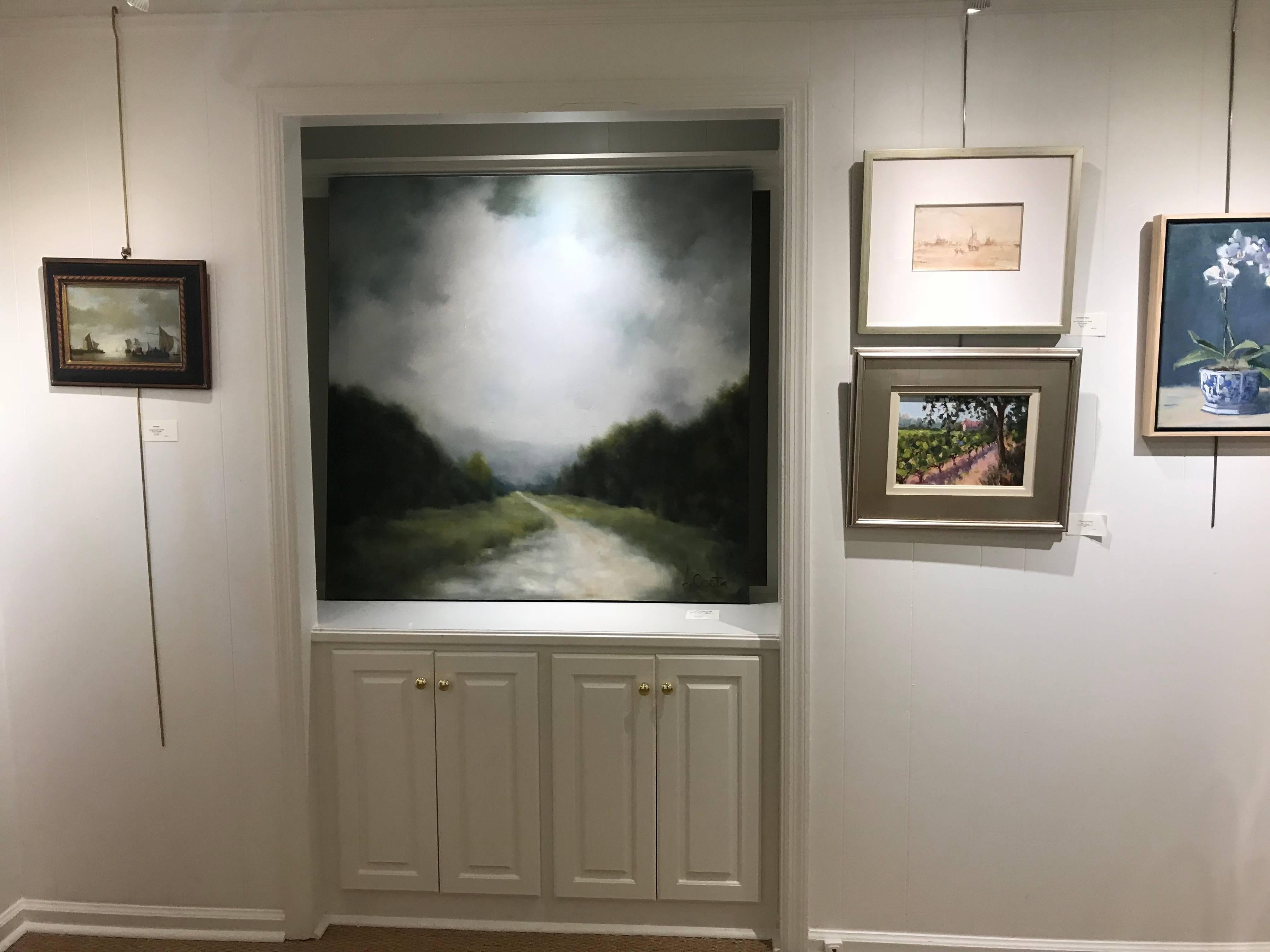 'Foggy Mountain 1' is an oil on gessoed canvas landscape painting created by American artist Andrea Costa in 2018. Featuring a delicately blurred landscape, the painting showcases a palette made of green, white, tan and grey. The overcast sky takes