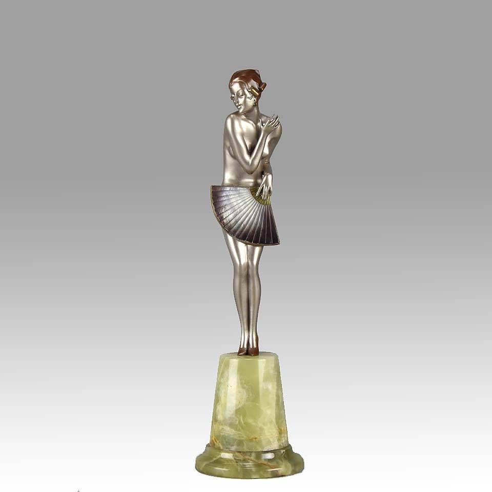 Gorgeous cold painted Art Deco bronze figure of a young woman, naked except for a fan that she holds in front of her to cover her modesty, her right arm across her chest in a coquette pose, the bronze with wonderful silvered patina highlighted with