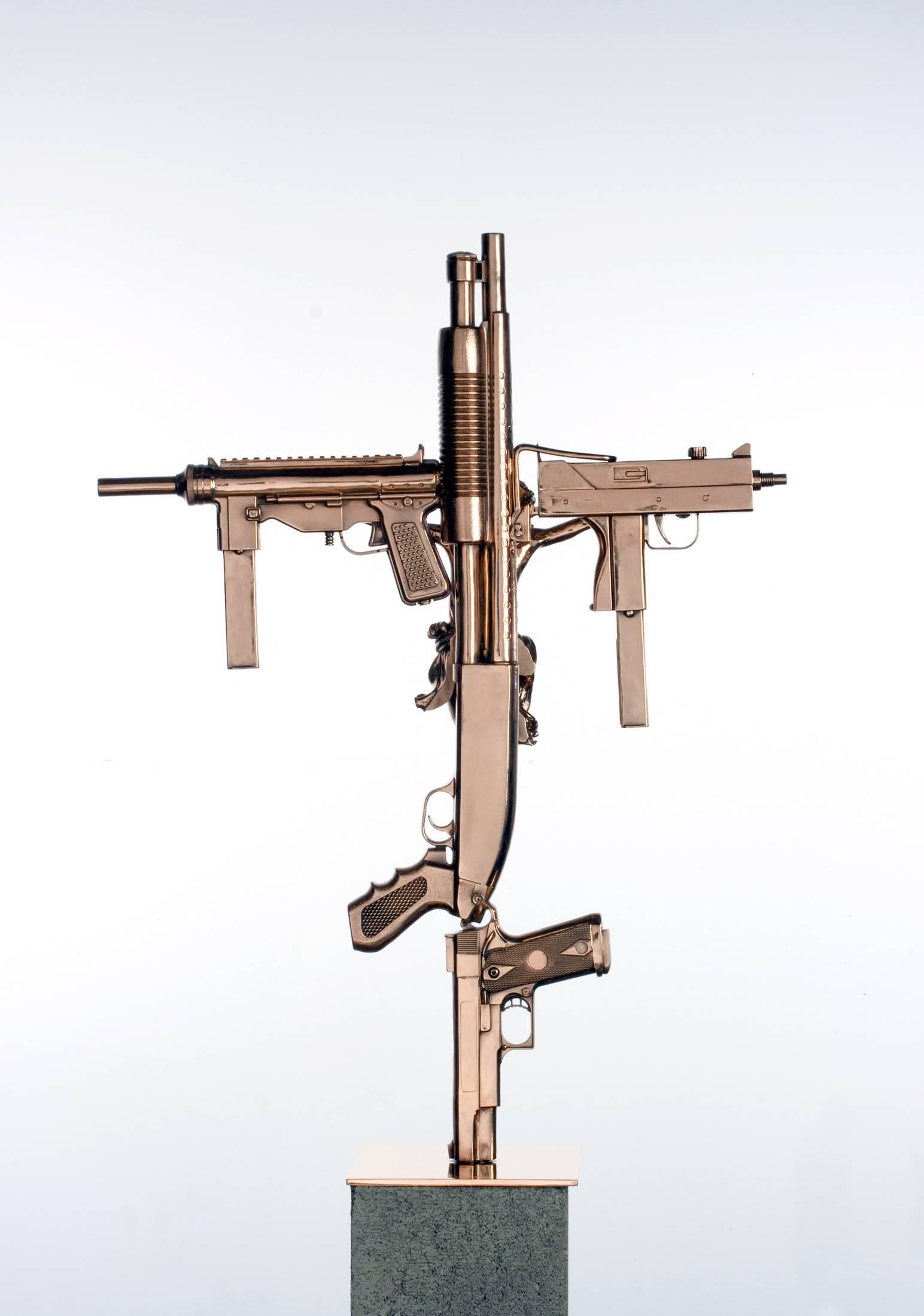 Contemporary sculpture comprised of cast bronze guns and crystal stones in the form of a crucifix. 

