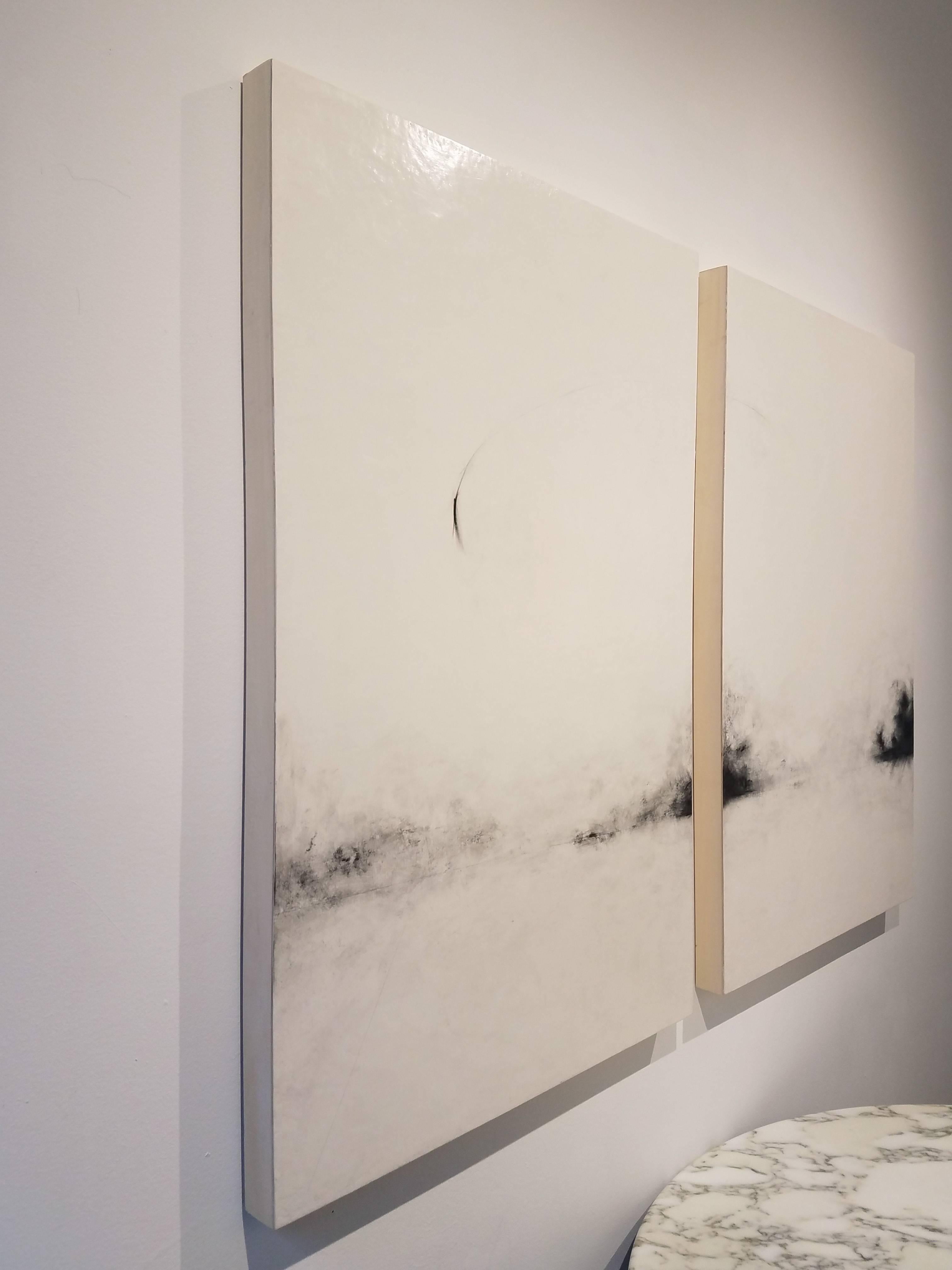 Nancy Hubbard, a mixed media artist, works primarily in black and white. To create this diptych, she applied a homemade gesso to two wood panels. 
She then drew a smokey, ethereal abstract landscape with charcoal and graphite. The piece is finished