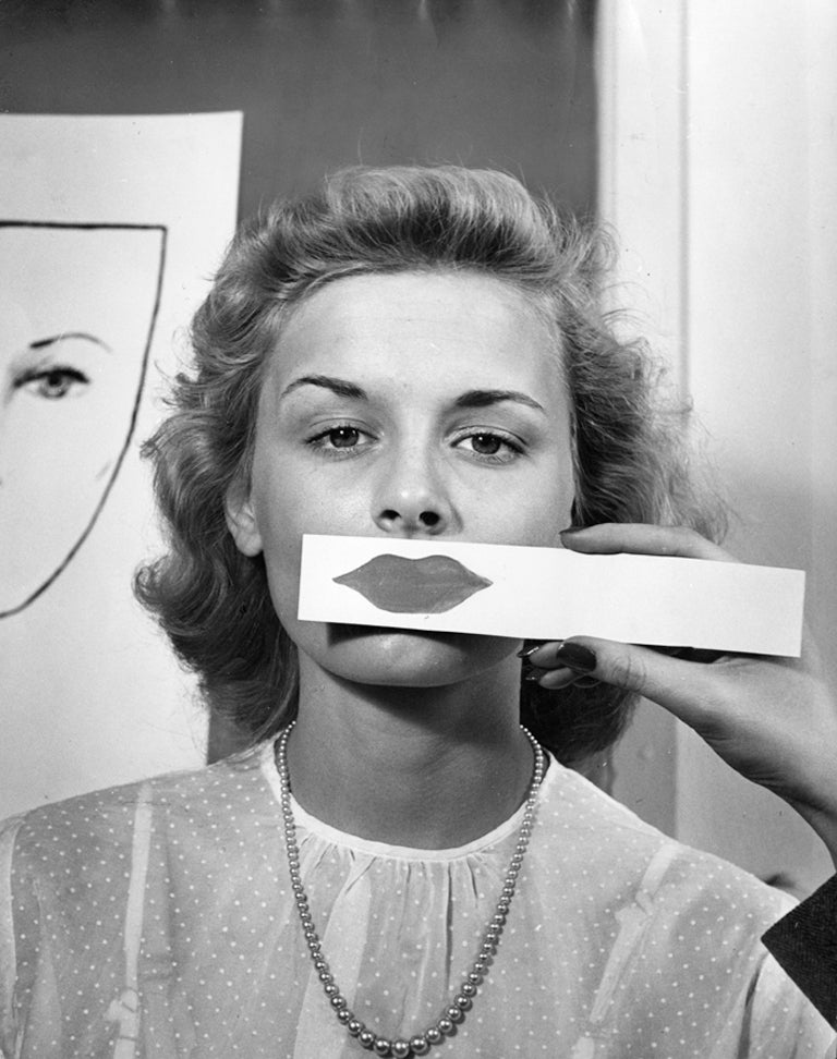 Nina Leen Black and White Photograph - Teenage Girl Tests Lipstick Shapes and Color