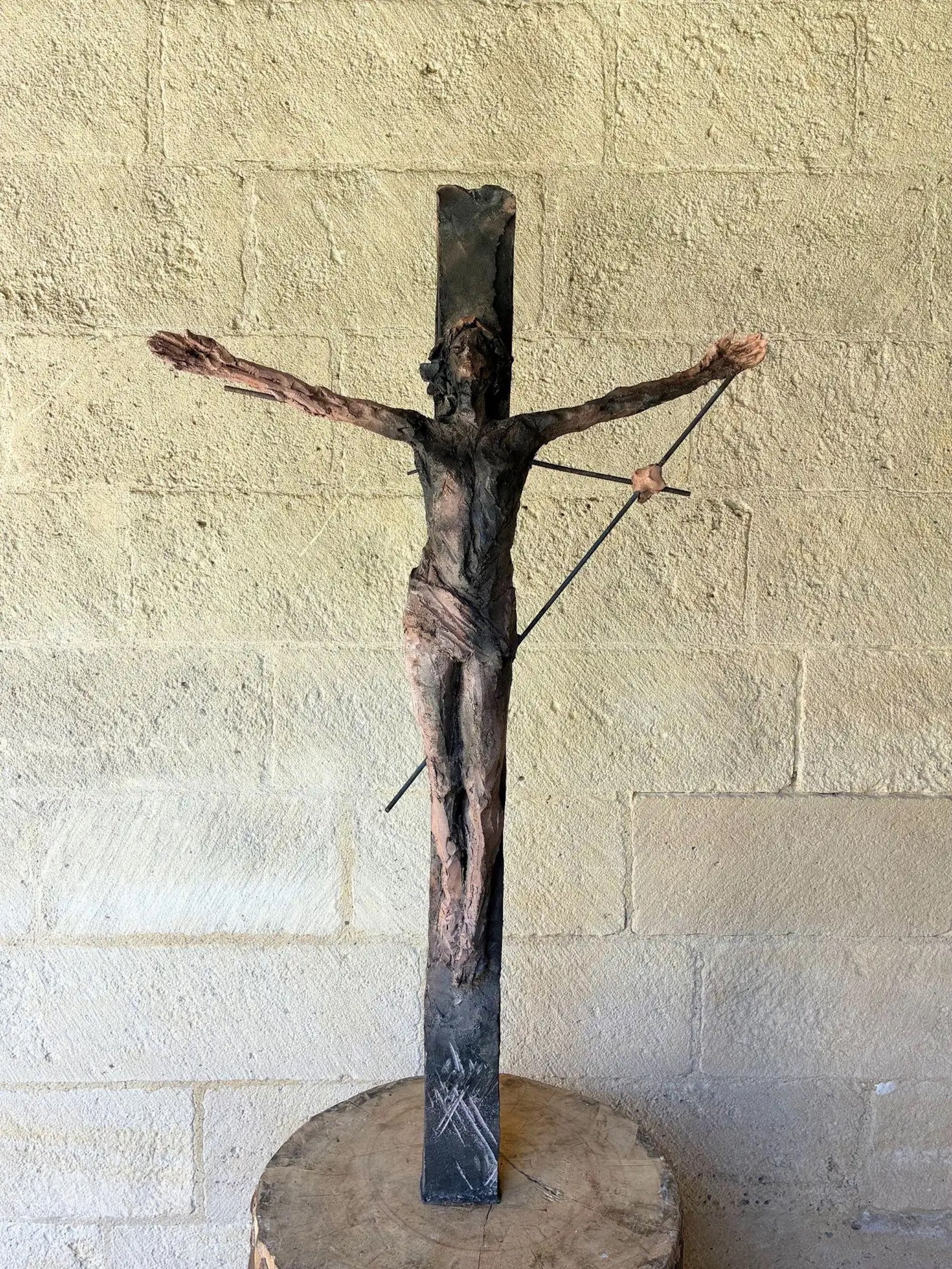 Un Christ è una scultura unica in gres cotto a fumo dell'artista contemporanea francese Cécile Raynal, le cui dimensioni sono 174 × 53 × 35 cm (68,5 × 20,8 × 13,7 in). Le dimensioni includono la base in legno (tavolo Wood).
Questa scultura è un