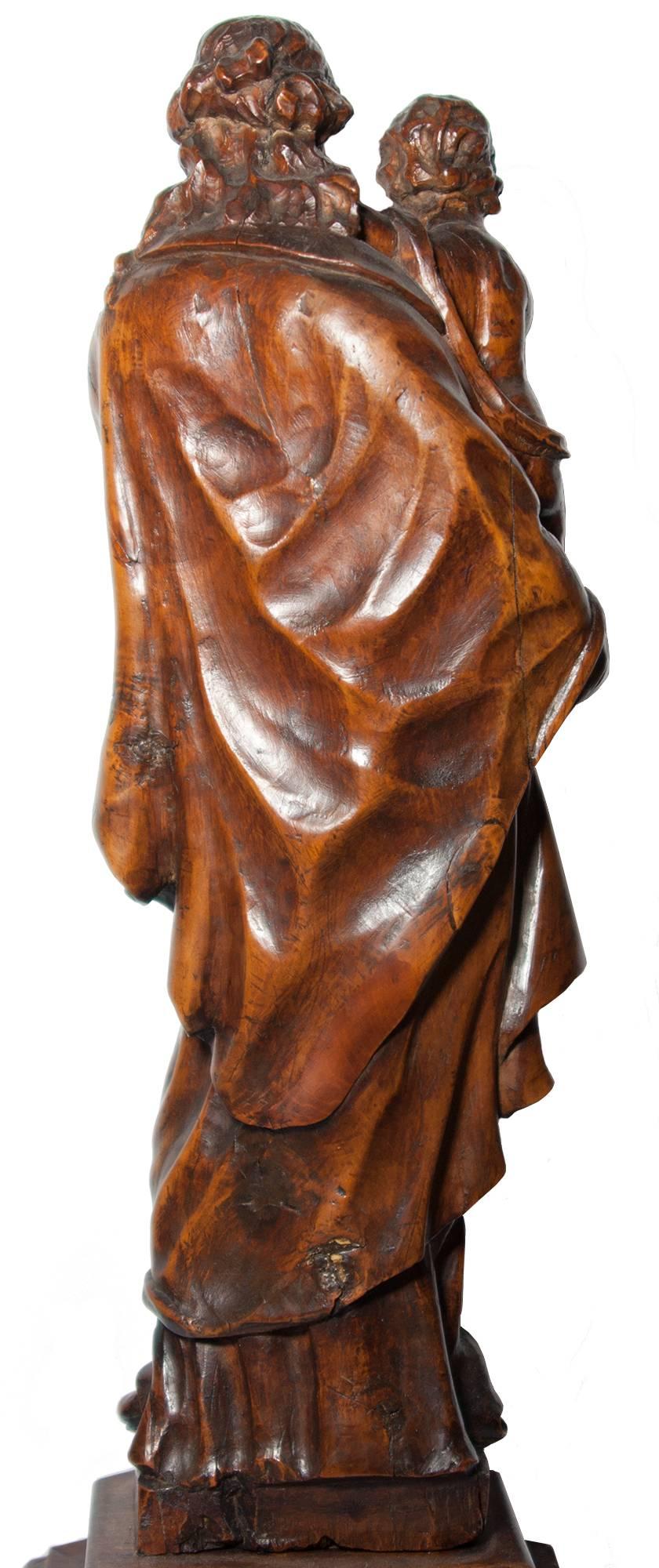 Beautiful figure of the Virgin holding the Child and the globe of royalty. The elegance of the elongated figure combined with a sophisticated drapery show a work of the Flemish School in the late XVII th, early XVIII th century. Carved in hardwood,
