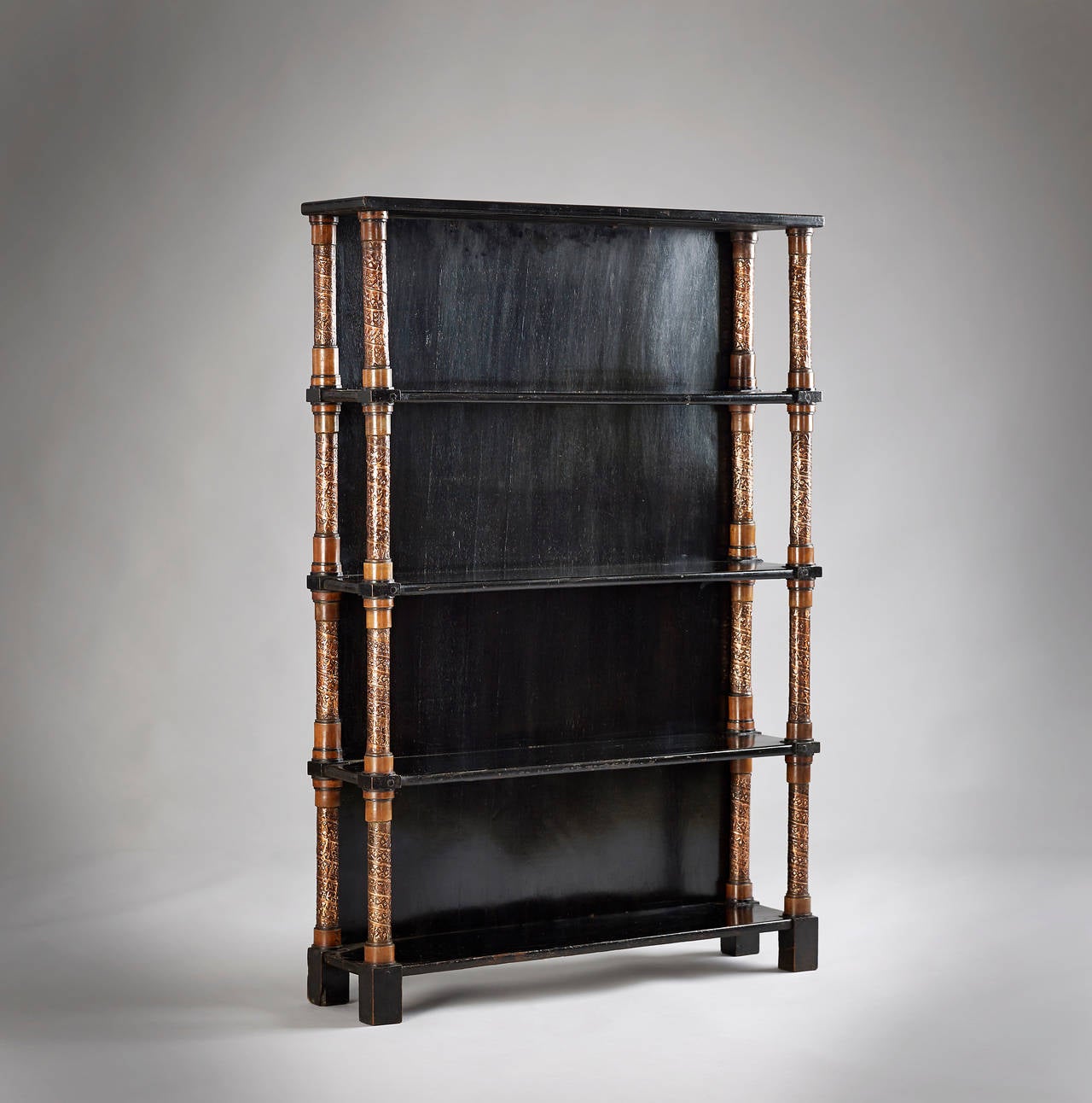 Walnut Bugatti Bookcase profusely inlaid with pewter. With hand beaten copper and hand painted decoration.

Carlo Bugatti worked with ceramics, musical instruments, silverware, and textiles, but he is best known for his furniture designs. The