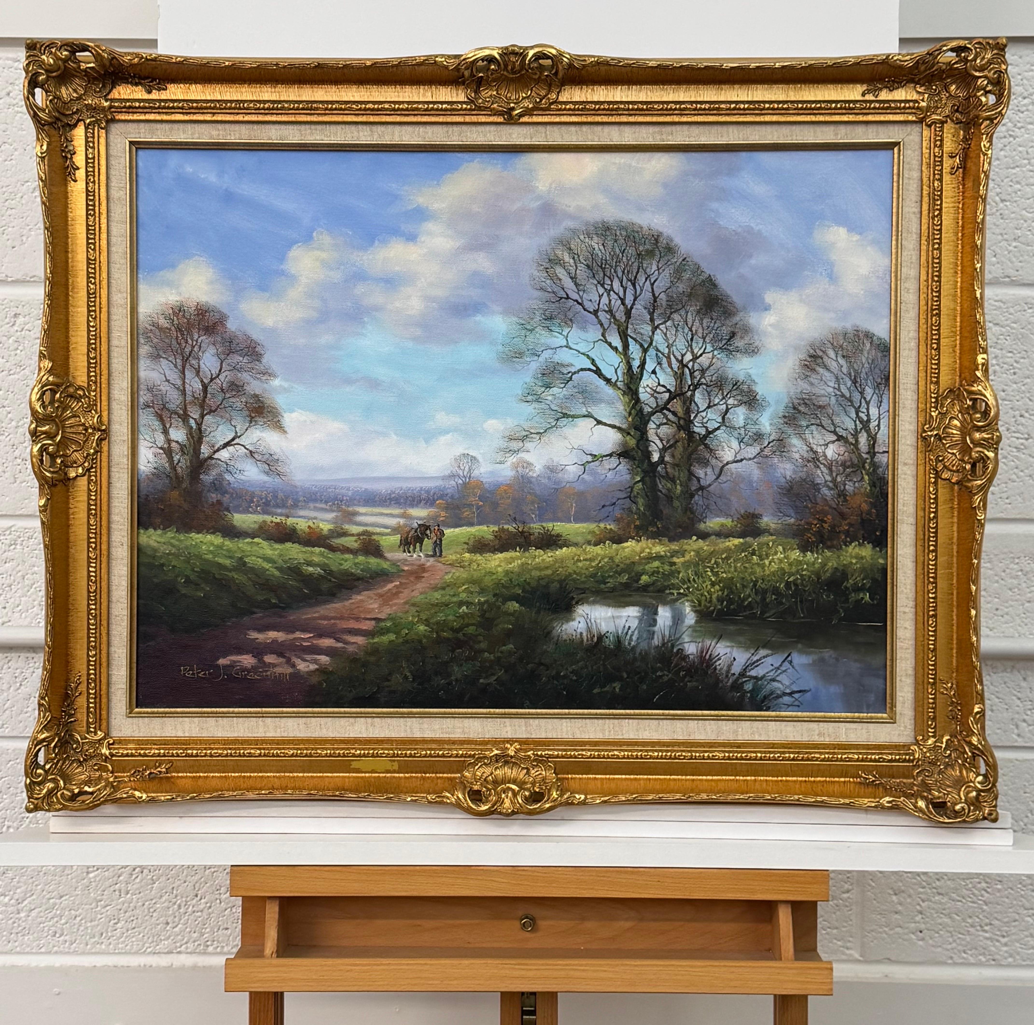 Caballo de Shire y hombre junto a río arbolado en la campiña inglesa por artista británico - Figurative Painting Marrón de Peter J Greenhill