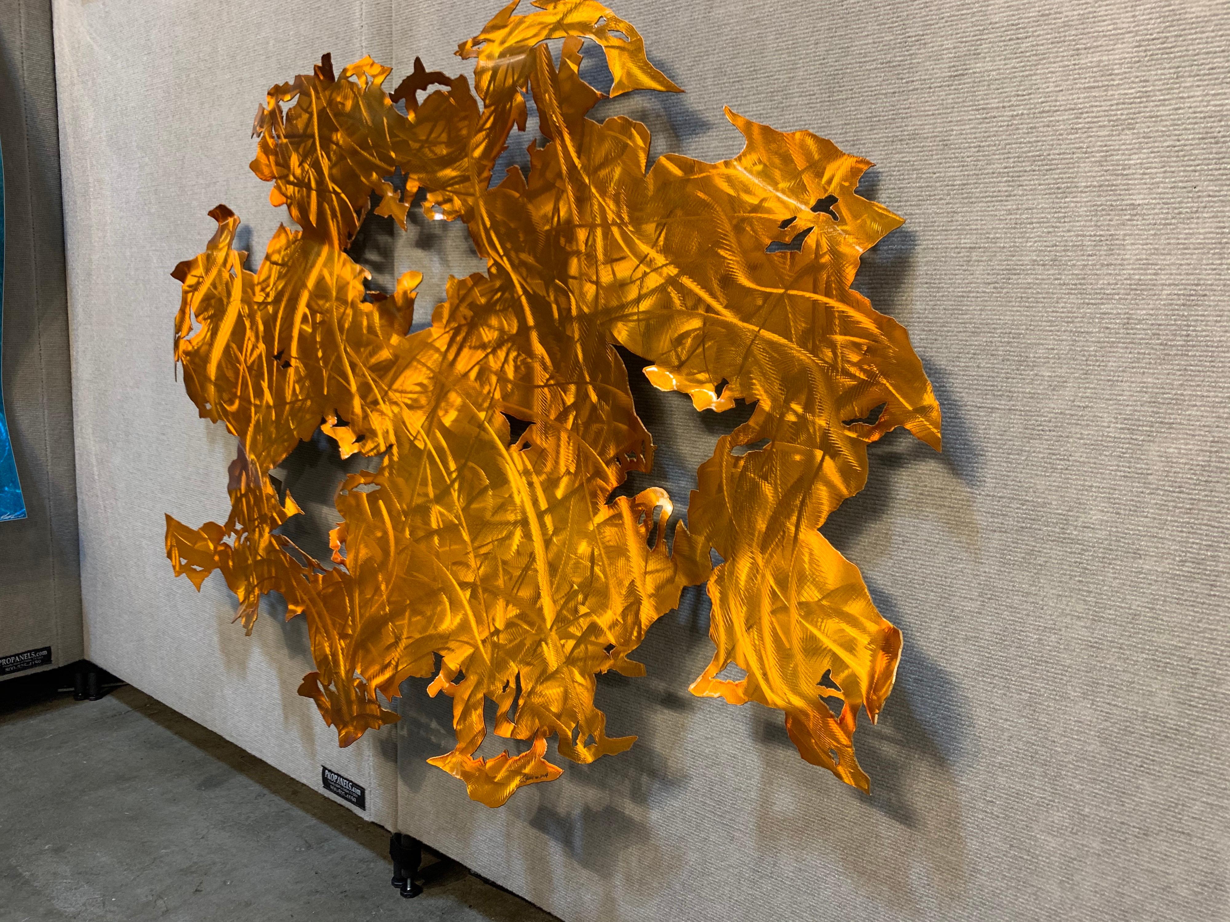 With warm tones of orange and red, this beautiful hand-ground aluminum wall sculpture will be a stunning addition to any modern, contemporary, traditional, or transitional home. The durable substrate and automotive clear coat finish make this piece