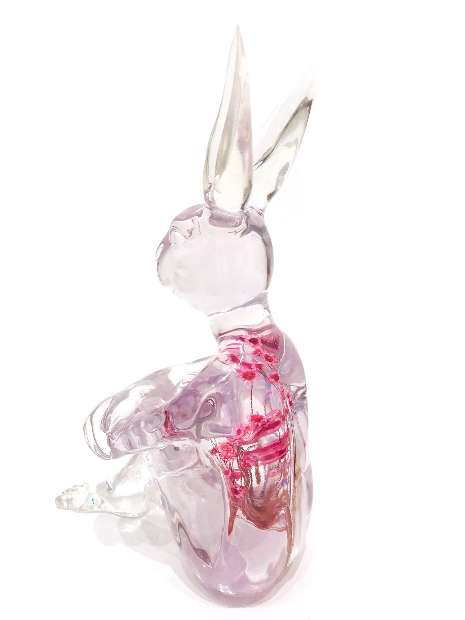 A whimsical yet very strong piece depicting the Rabbit from Gillie and Marc's iconic figures of the Dog/Bunny Human Hybrid, which has picked up much esteem across the globe. Here we find Rabbit sitting crossed legged and with beautiful pink flowers
