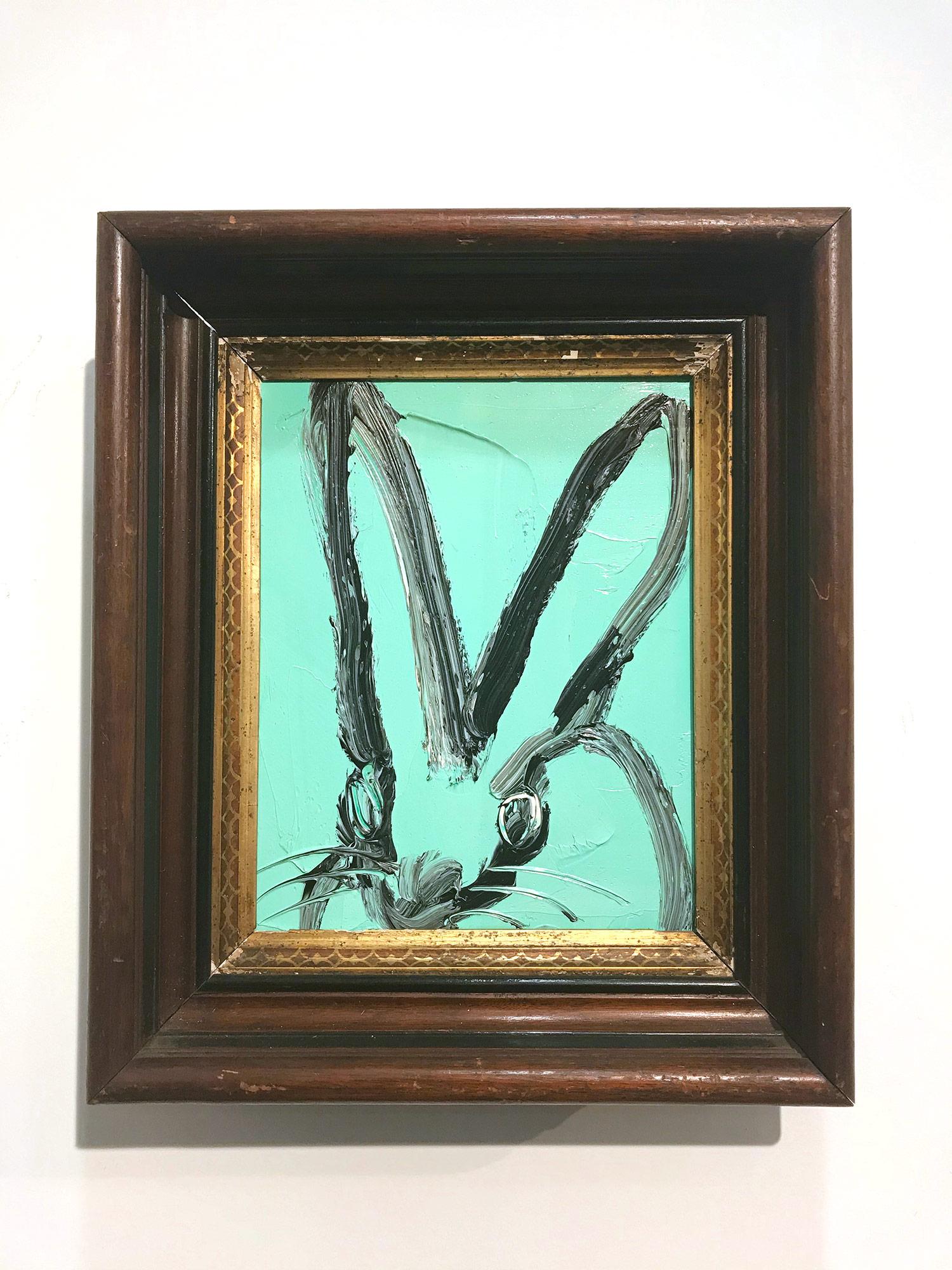 A wonderful composition of one of Slonem's most iconic subjects, Bunnies. This piece depicts a gestural figure of a black bunny on a Periwinkle blue background with thick use of paint. It is housed in a wonderful carved wood frame. Inspired by