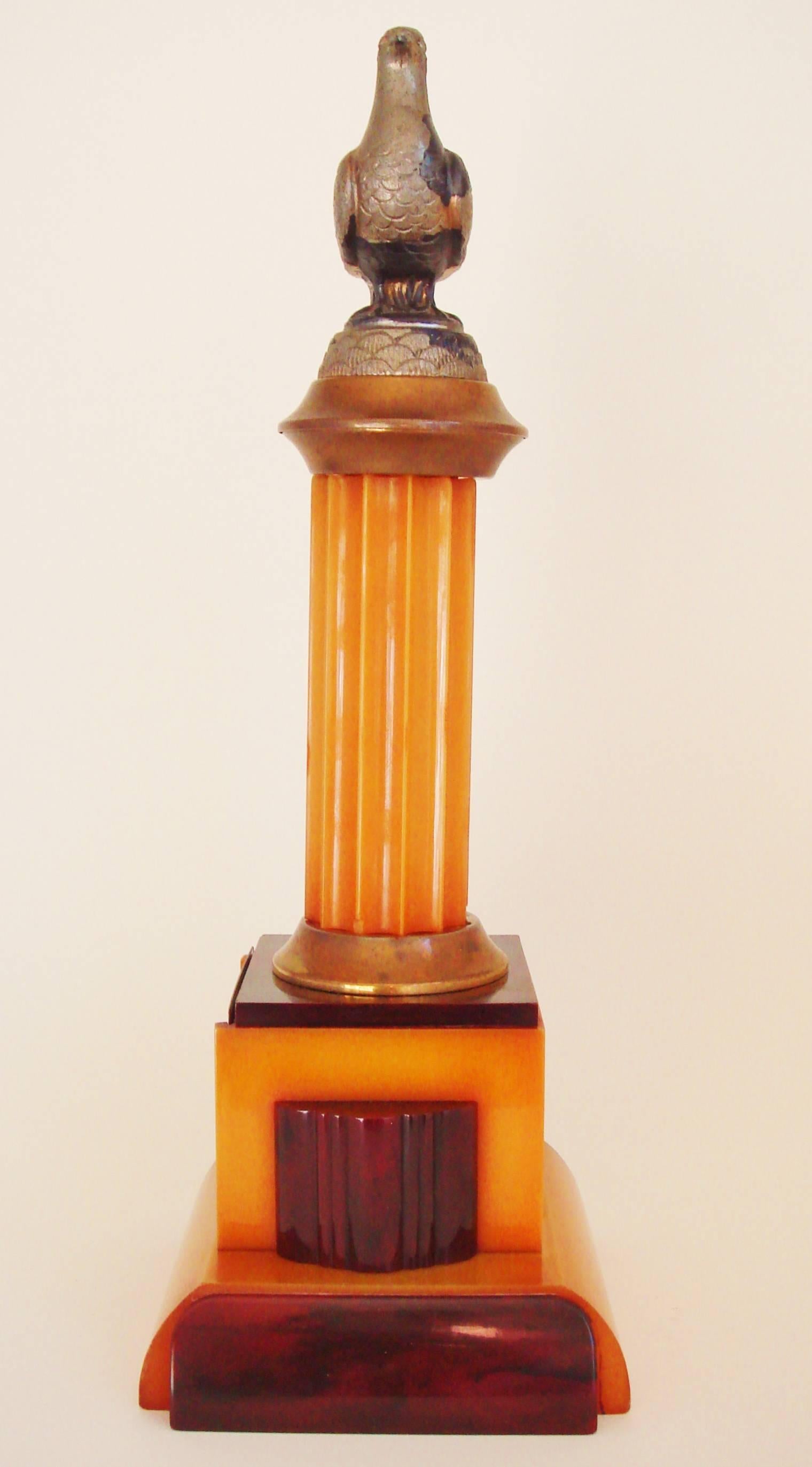 This rare American Art Deco pigeon racing trophy features a very architecturally designed fluted base column in yellow and marbled burgundy Catalin Bakelite with the yellow areas having aged to a rich amber. It was made by the long established