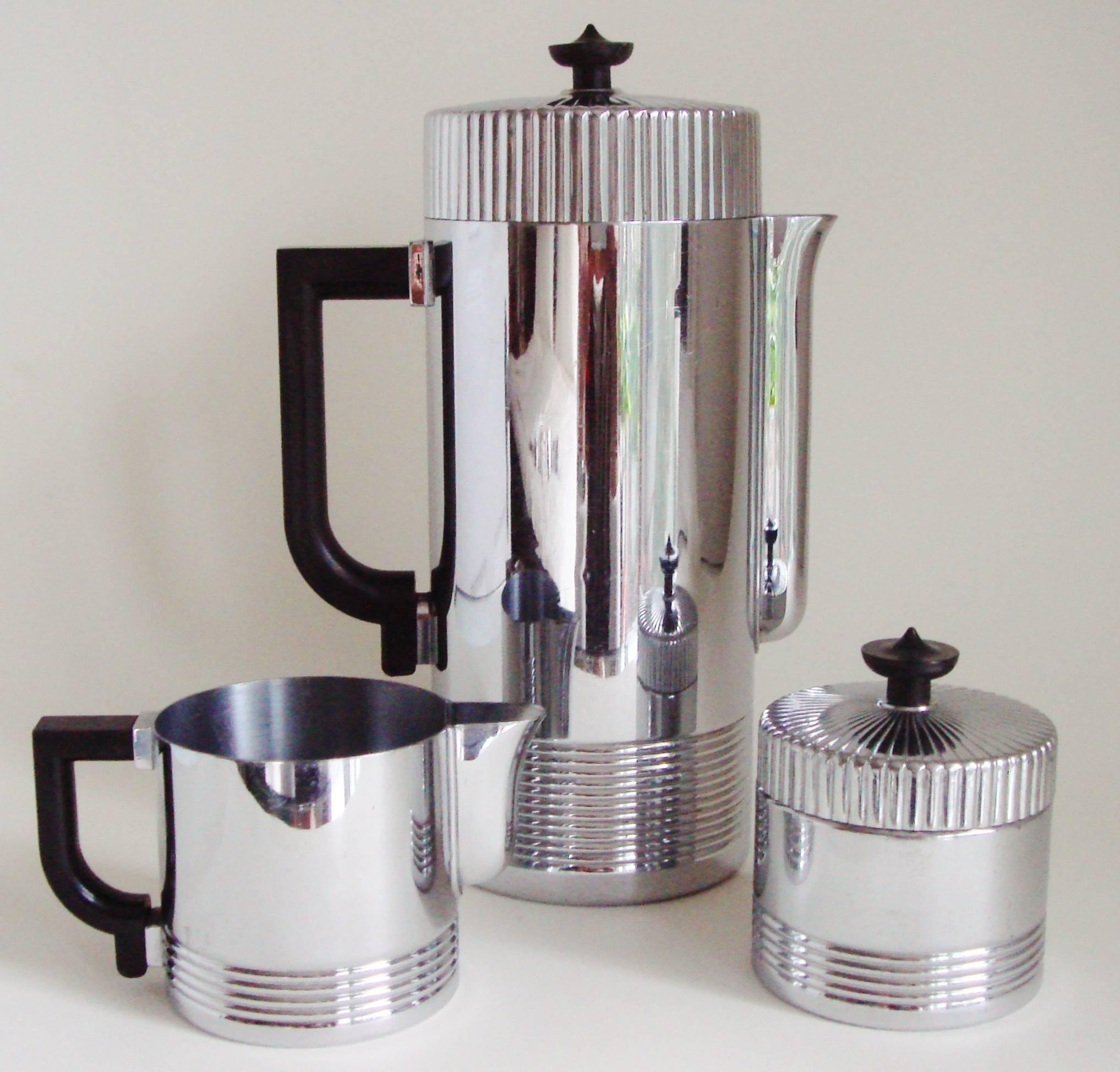 Walter Von Nessen's iconic design for the Chase Brass and Copper Company for their Continental Coffee Service is here presented in both of its versions. This set combines the more famous chrome with black Bakelite handles and knops (1935 Catalogue)