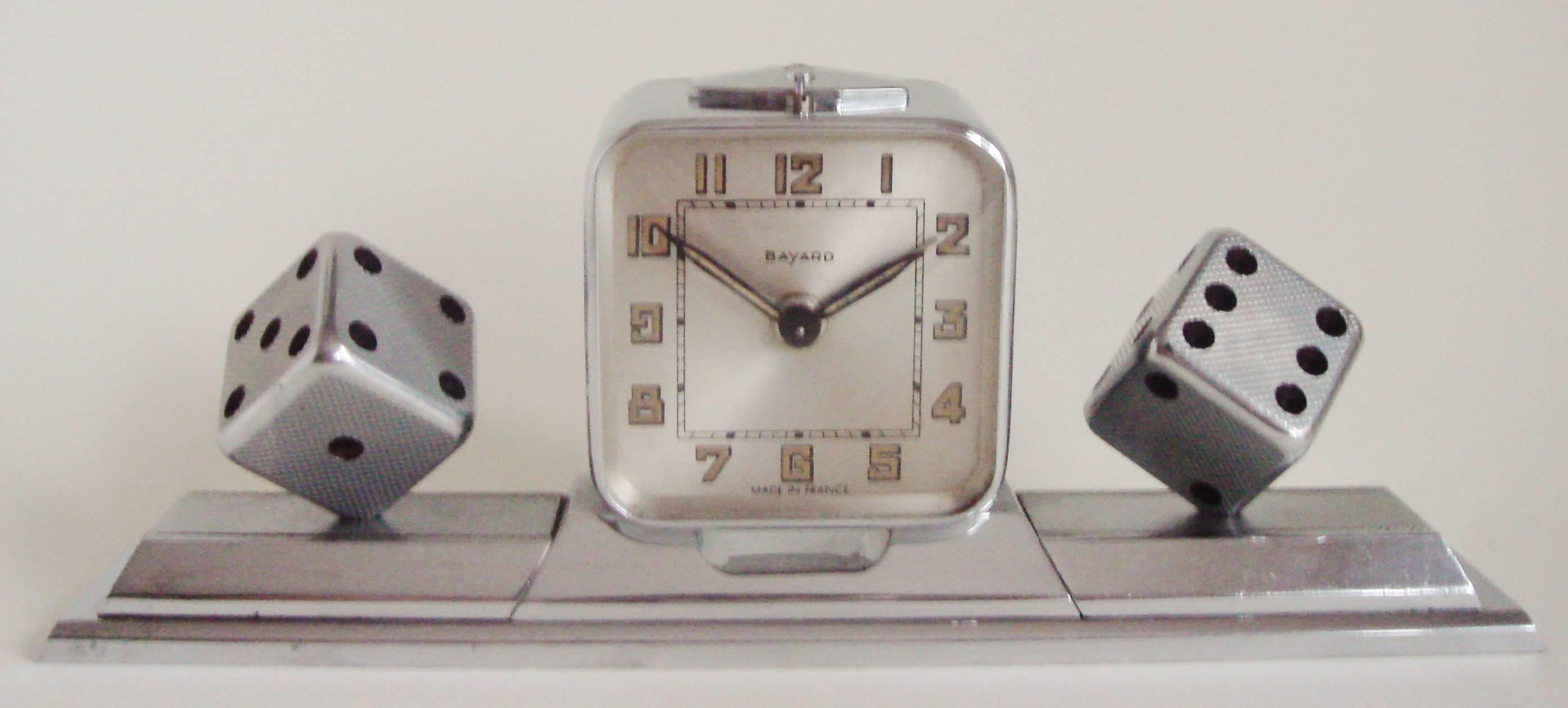 This beautifully engineered French Art Deco desk set features a chrome-plated brass Bayard mechanical alarm clock mounted on a heavy chrome plated bronze base. This clock is flanked on either side by a detachable plated bronze paperweight each with