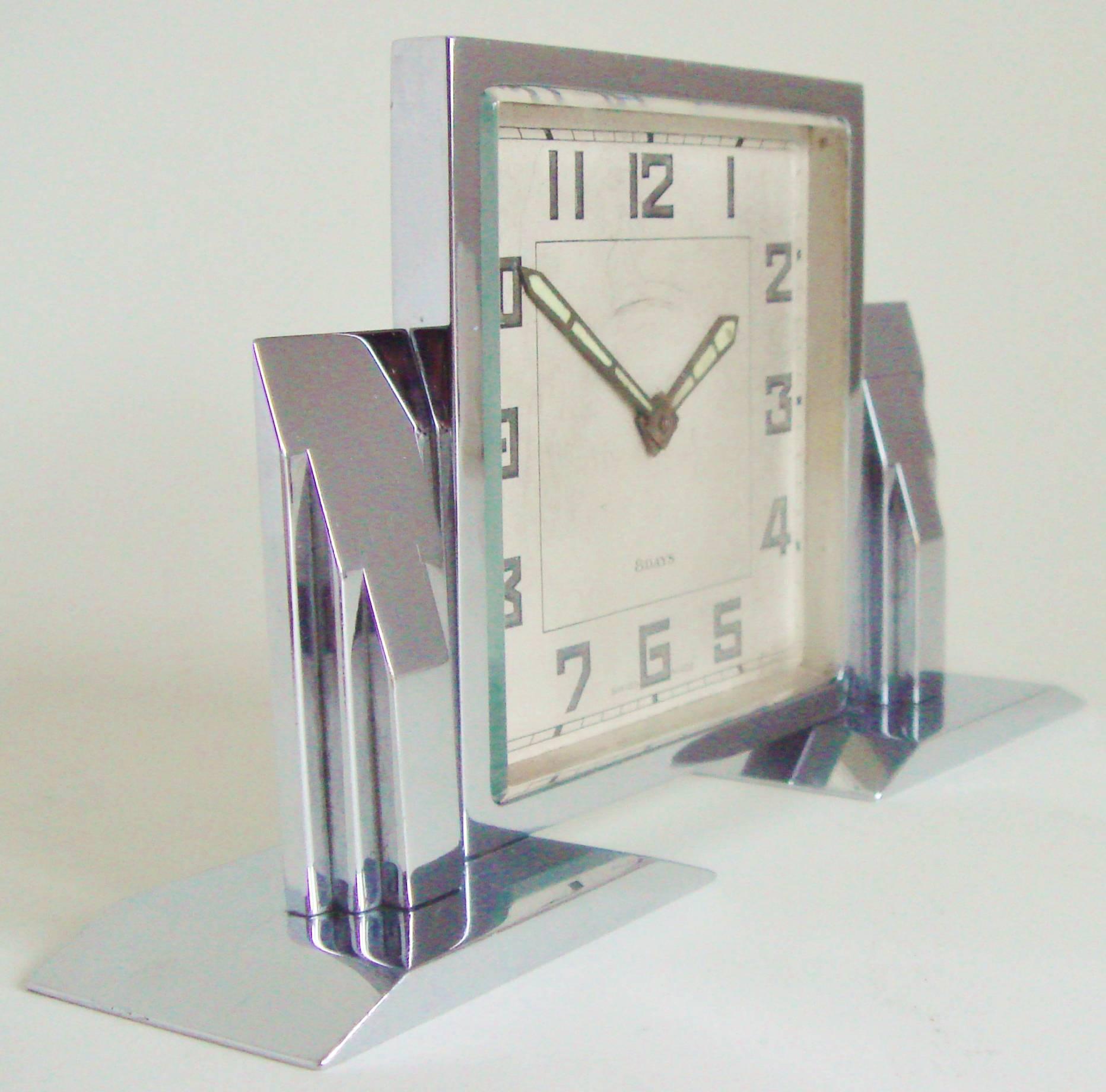 This is a beautiful and architecturally designed small Swiss Art Deco mechanical eight-day desk clock. It has its original chrome plate to both the front and back which is near perfect condition. The face shows only light age and there is a slight